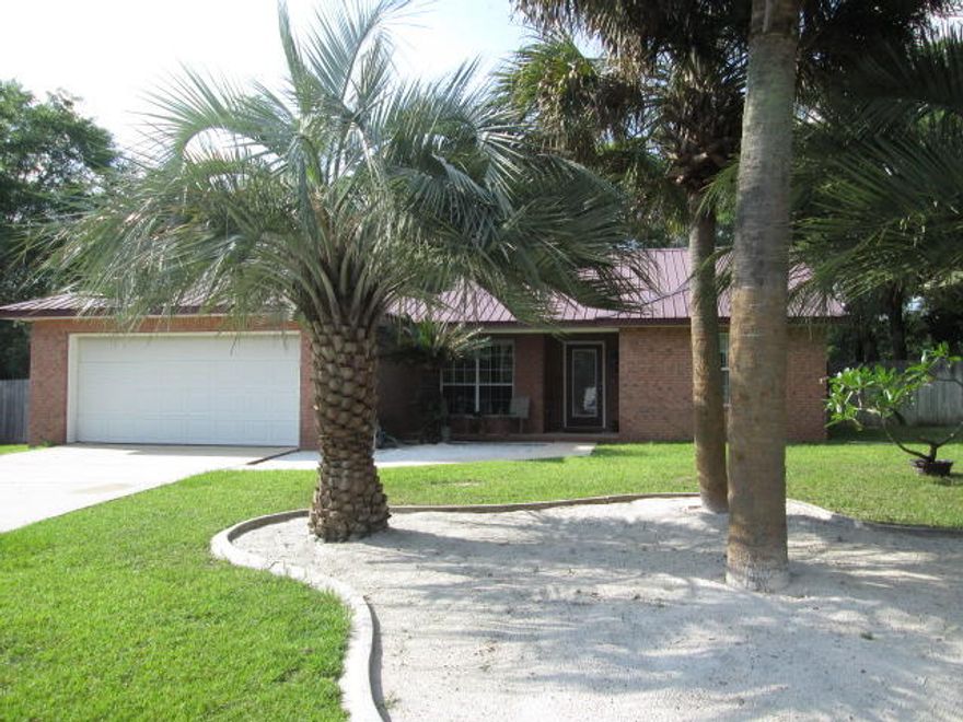Pride in ownership is very apparent in this lovely brick home located south of I-10 and just a hop, skip and jump away from Duke Field. Home features a newer HVAC system, upgraded lights and tin roof. A beautifully maintained front yard, complete with palm trees, greet you as you drive into the driveway,The home's spacious family room has a cathedral ceiling, lovely ceiling fan, plenty of wall space and wood burning fireplace.A bay window adds plenty of natural light to the breakfast area while the kitchen, with tile flooring, has plenty of counter space, cabinets and a breakfast bar for extra seating.Split bedroom floor plan allows for privacy. Spacious master bedroom provides plenty of room for large furniture. Master bathroom features a corner garden tub, separate shower and walk.