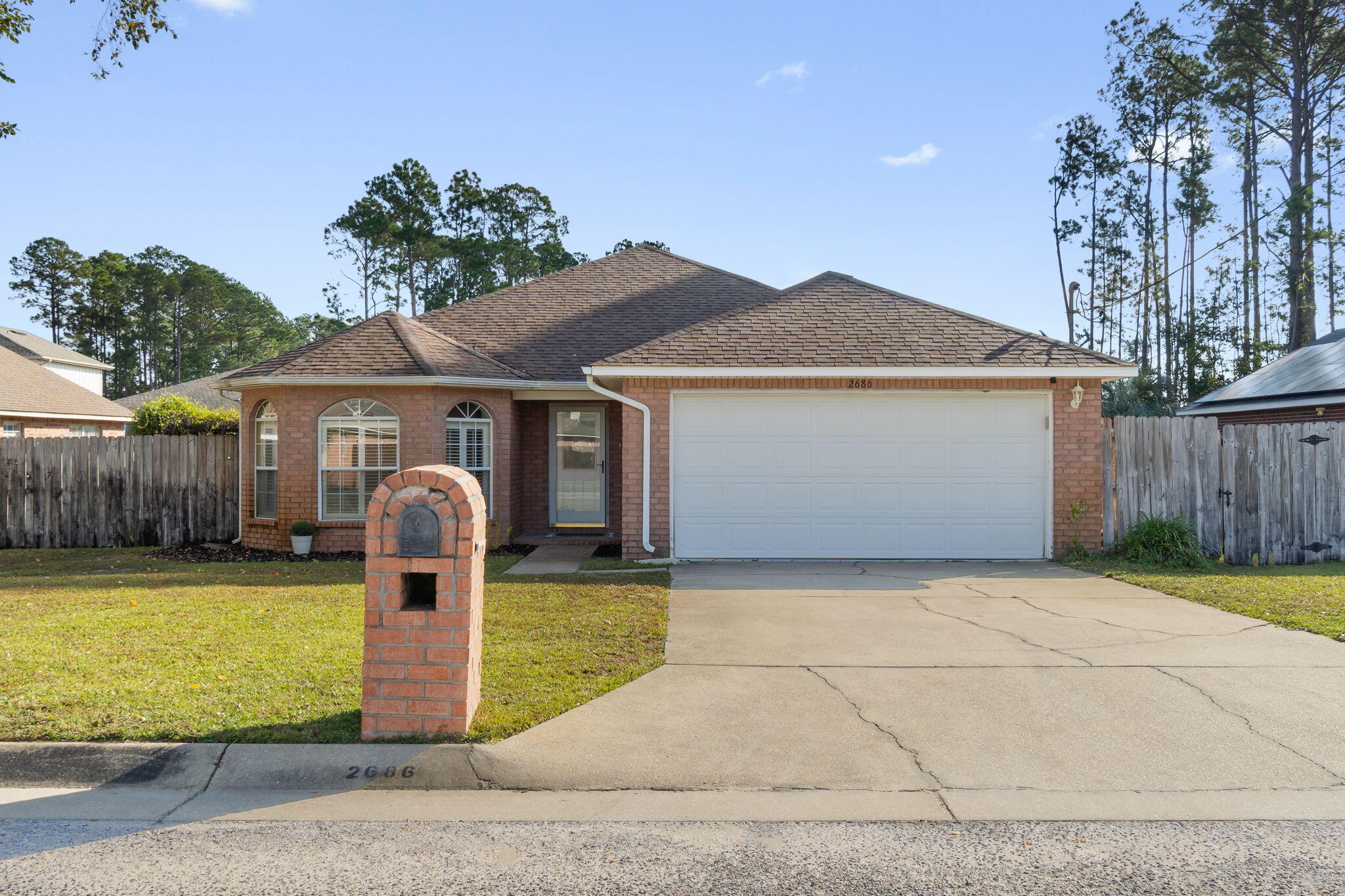 Welcome home to this adorable all brick 3 bedroom home in the charming neighborhood of Hidden Estates! Enter in the front door and appreciate the vaulted ceiling and wood plank flooring throughout the oversized living room complete with a stunning brick focal point fireplace! The eat in kitchen area leads to the well appointed and updated kitchen complete with granite countertops, stainless steel appliances, a huge single basin stainless steel sink, and brushed nickel hardware and fixtures. This split floor plan has a great sized owner's suite with a trey ceiling as well as double vanities, two walk in closets, a soaking tub, and a separate shower. The other two bedrooms on the other side of the home have plantation shutters, ample closet space, and the front bedroom has delightful bay windows allowing for tons of natural light! The interior laundry room leads to the 2 car garage where you'll find a built in work bench. Outside through the sliding back glass door is a covered patio overlooking the flat and fenced in backyard (playset can convey!) to enjoy!