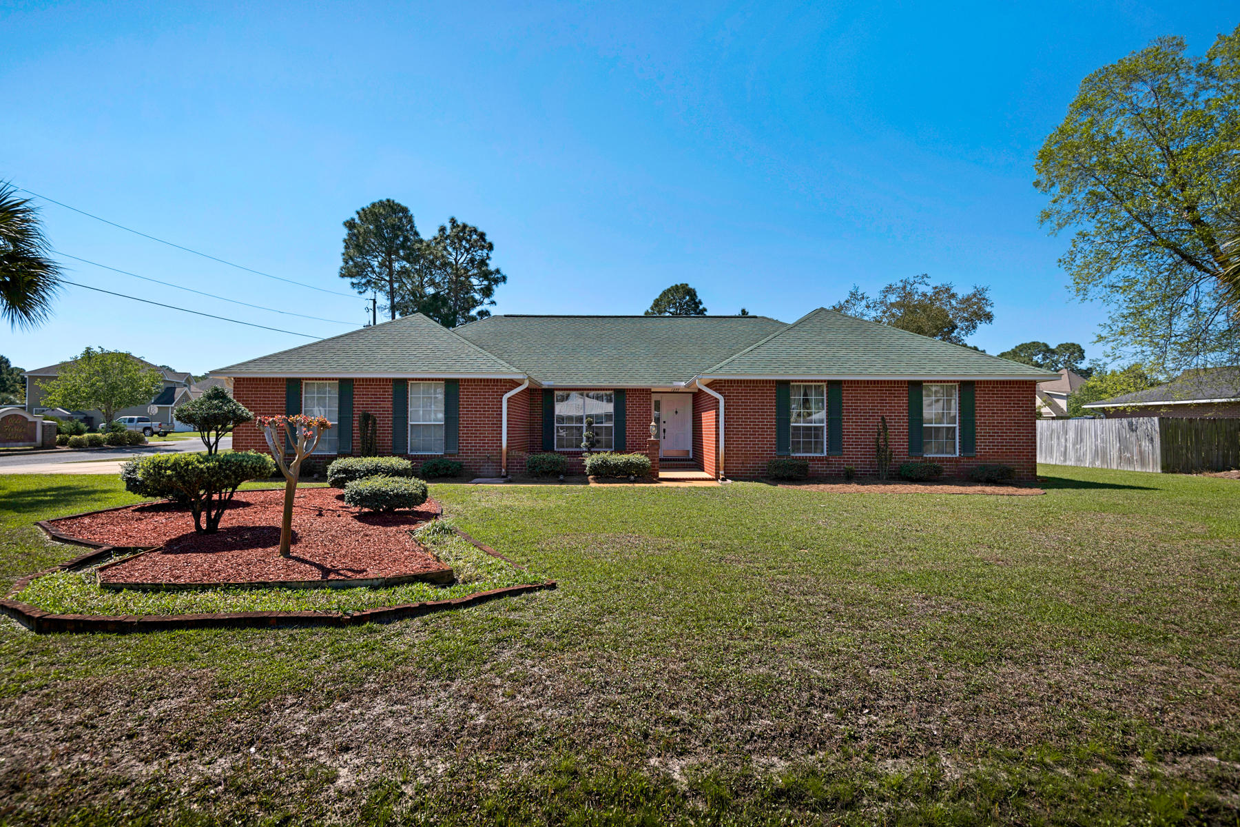 Attractive Brick Home Offers Low Maintenance Lifestyle Near Beaches /Holiday Shores Estates in Miramar Beach is a nice neighborhood with large lots and friendly people. The livin' is easy in this neat and tidy one level, traditional red brick home on 1/3 acre. The living room is spacious with double doors outside and lovely neutral tones. A formal dining room with large windows is perfect for entertaining. The dining nook with its large bay window is as charming as the adjacent kitchen with custom light birch cupboards. Recessed lighting, white appliances and granite countertops are the perfect complement to wood parquet floors. It's light, bright, functional and very inviting.The bathrooms and bedrooms are immaculate with custom window treatments and wood valances in the master.