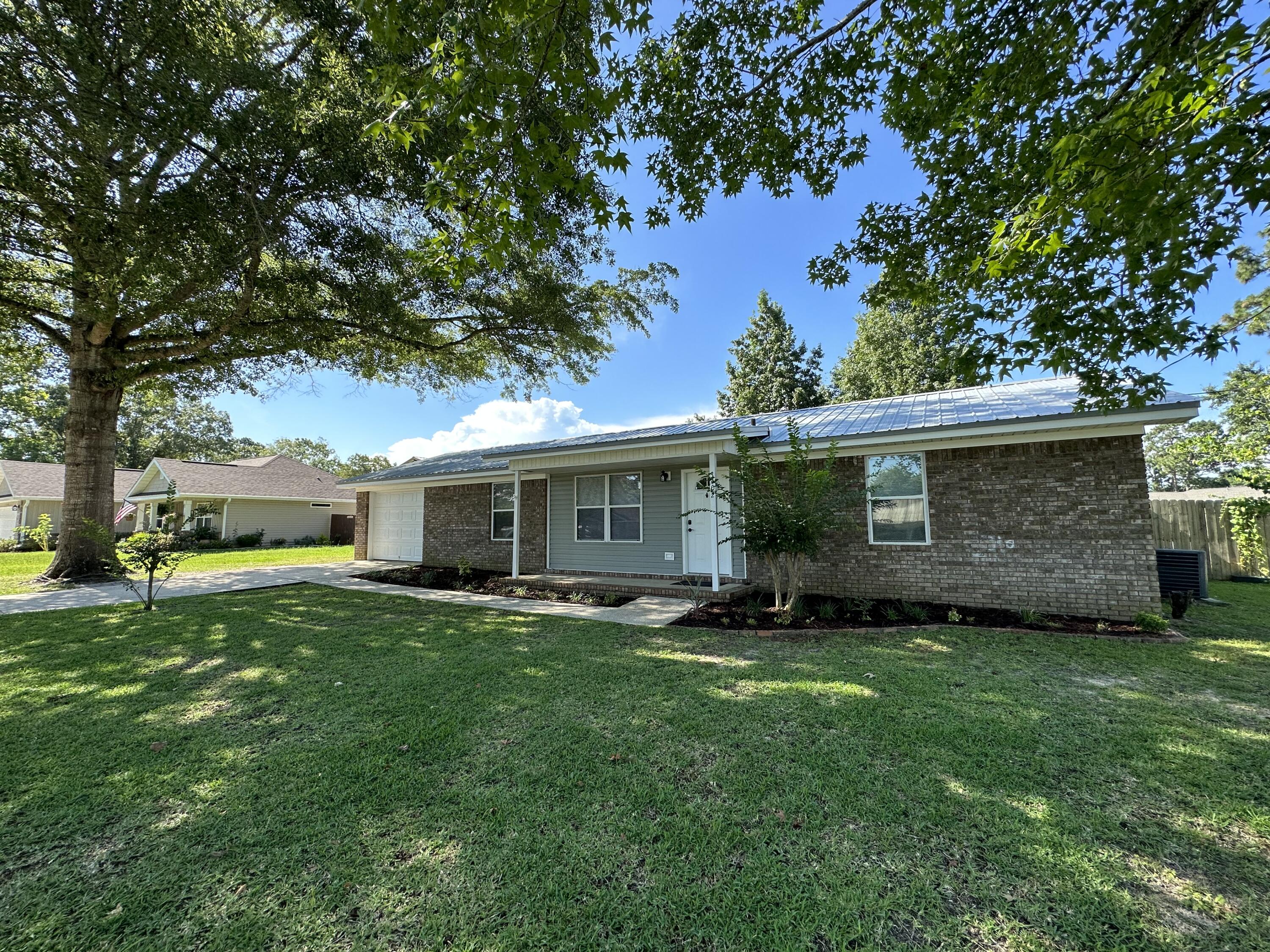 Don't miss this charming homesite! Notice the beautiful landscaping in the front and back yard, with plenty of shade trees for those summer days. The backyard is privacy fenced with sidewalks/ a grilling area and gives plenty of space for your boat or RV and a 12x12 tool shed.This 4 bedroom 2 bathroom home with a converted garage, gives endless options to meet your needs.The double-pane windows throughout the home create a light and bright atmosphere. Lots of upgrades! All brick, metal roof, front and rear porches ,level, fenced ! If you're heading to the beach or making a grocery run, this property gives easy access to both Hwy 85 and Hwy 90.