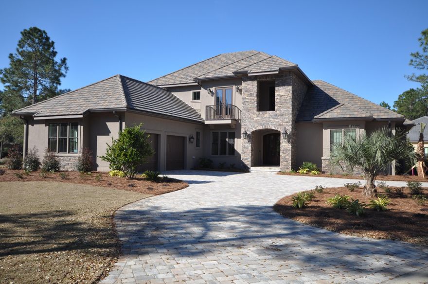 Brand new Randy Wise home! This estate makes a grand statement as you enter Island Green, the most prestigious community outside of Burnt Pine. Located on almost a .5 acre corner lot, this home boasts more than 7000 SqFt of indoor and outdoor space! Special features include a 2.5 car garage, enclosed lanai and pool deck with complete outdoor kitchen, first floor master suite and study area, optional elevator, all granite counter tops, hardwood flooring throughout, carpet flooring in the bedrooms, living room fireplace, and much more. The second floor features three additional bedrooms, two baths, and a loft area. Lovely views of the lake and 5th fairway of the Raven Golf Course. This home is a must see!