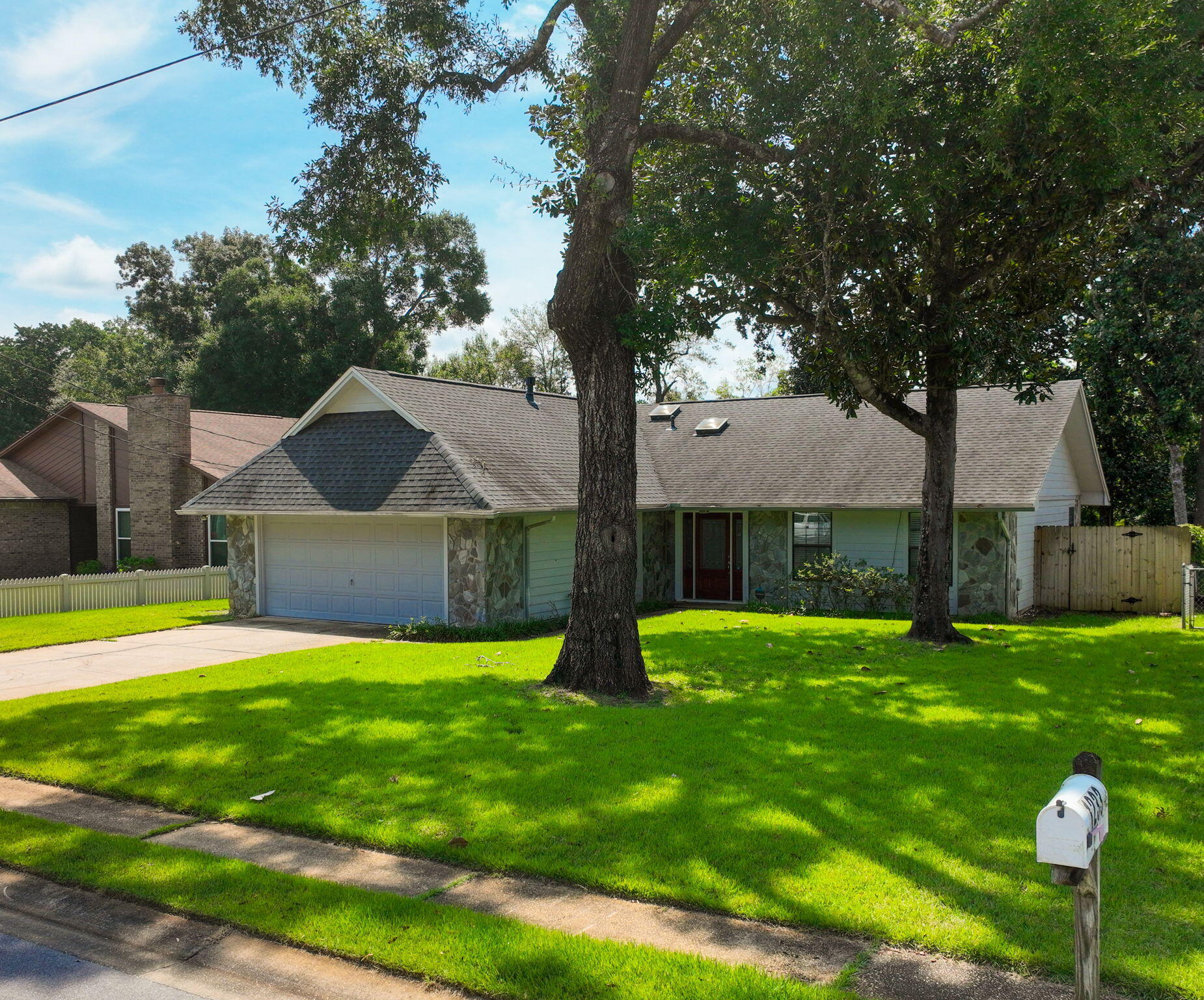 Beautifully updated home in the heart of Niceville! This property features an open and inviting layout with a spacious living area, vaulted ceilings, and a cozy stone fireplace. The kitchen shines with granite counters, stainless appliances, and plenty of cabinet space. Both bathrooms are modern and stylish, and all bedrooms are generously sized. Enjoy wood-look tile in the main living spaces, fresh carpet in bedrooms, and a large fenced backyard that gently slopes to Swift Creek -- a serene outdoor retreat. Conveniently located near bases, schools, shopping, and just a short drive to the beaches of the Emerald Coast. Move-in ready and waiting for you!