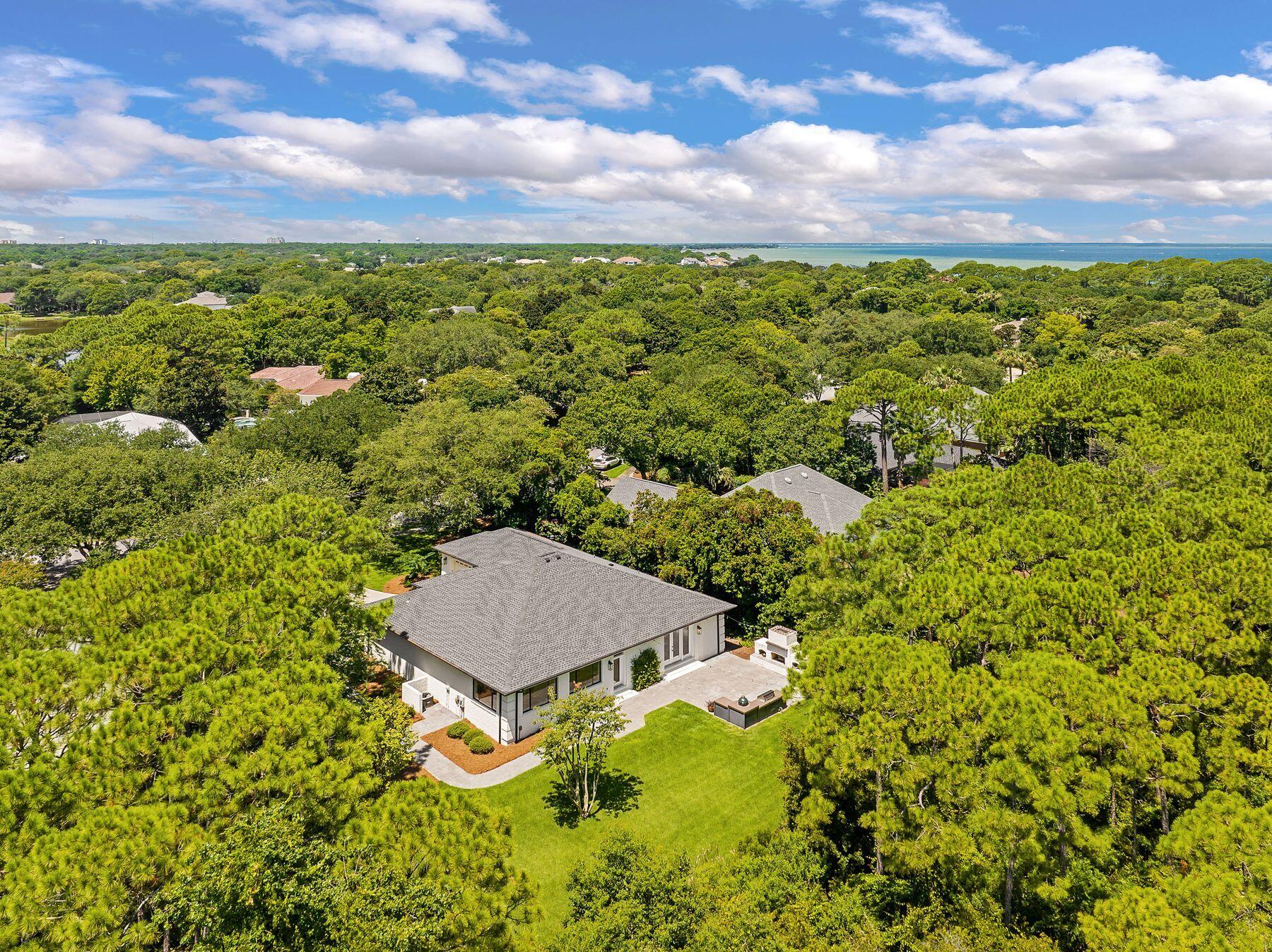 Set on a generous .41-acre lot within the exclusive gated enclave of Kelly Plantation, this refined single-level home offers both privacy and connection to nature with its peaceful backdrop of lush, protected preserve. Built with enduring quality, the residence features brick over concrete block, a 2021 shingle roof, water heater, HVAC and modern interior updates. The welcoming foyer opens to airy, light-filled living spaces, including a gourmet kitchen with shiplap accents, quartz countertops, a monochrome island, and abundant cabinetry. Ideal for casual mornings or lively gatherings, the kitchen flows into a sitting room anchored by a modern horizontal fireplace. A formal dining room and a versatile bonus room provide options for entertaining or everyday living. The split floor plan offers four spacious bedrooms and two stylish baths. The master suite enjoys serene preserve views through oversized picture windows, with an ensuite bath featuring a soaking tub, frameless glass shower, and striking herringbone tile work. Outdoors, a thoughtfully cleared backyard with room for a pool, creates space for an inviting seating area with an outdoor fireplace, summer kitchen, Big Green Egg and fire pit - perfect for quiet evenings or festive gatherings. Just beyond your doorstep, residents enjoy a wealth of community amenities, including an award-winning golf course, owners' clubhouse, fitness center with yoga studio, tennis and pickleball courts, riding stables, basketball and beach volleyball, community docks, playgrounds, and scenic walking trails. With the middle school a short stroll from the back gate and a new high school nearby, this move-in ready home pairs comfort, convenience, and an enviable lifestyle in one of Destin's most sought-after communities.
