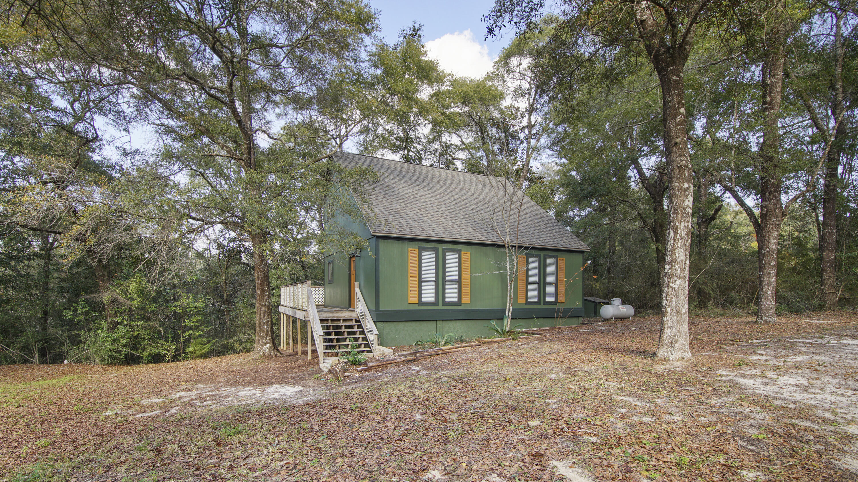 Charming, fully updated cabin nestled on a peaceful, wooded 1 acre lot, located perfectly between DeFuniak Springs (appx 7-10 min to downtown) and Crestview. Looks and feels more like the mountains than FL! Sweeping scenic views from both lower and upper decks. The soaring ceilings make this 1200sf home feel much larger. With new paint and lighting inside and out, new roof and new HVAC, there's no deferred maintenance worries. The LVP is also newer in a light, neutral shade. The master suite is on the main floor, with new double vanity and new tile shower with laundry included. Upstairs is the 2nd bedroom and bath with balcony, alongside a loft space that would be great for a home office (or could even be converted into a 3rd bedroom). This is a can't miss home - or even an Airbnb!