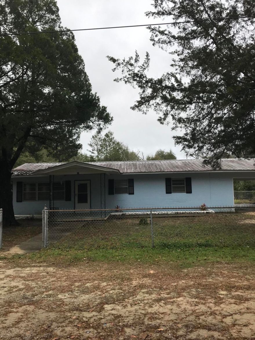 Great house!  Just been painted, and has new carpet.  Super large kitchen and dining area.  Living room has beautiful stained tongue and groove paneling.  Newly remodeled full bath.  Laundry is in separate building with 1/2 bath.  Drive through carport. Over sized lot.  Over an acre! Partially fenced with chain  link. Nice place to call home!