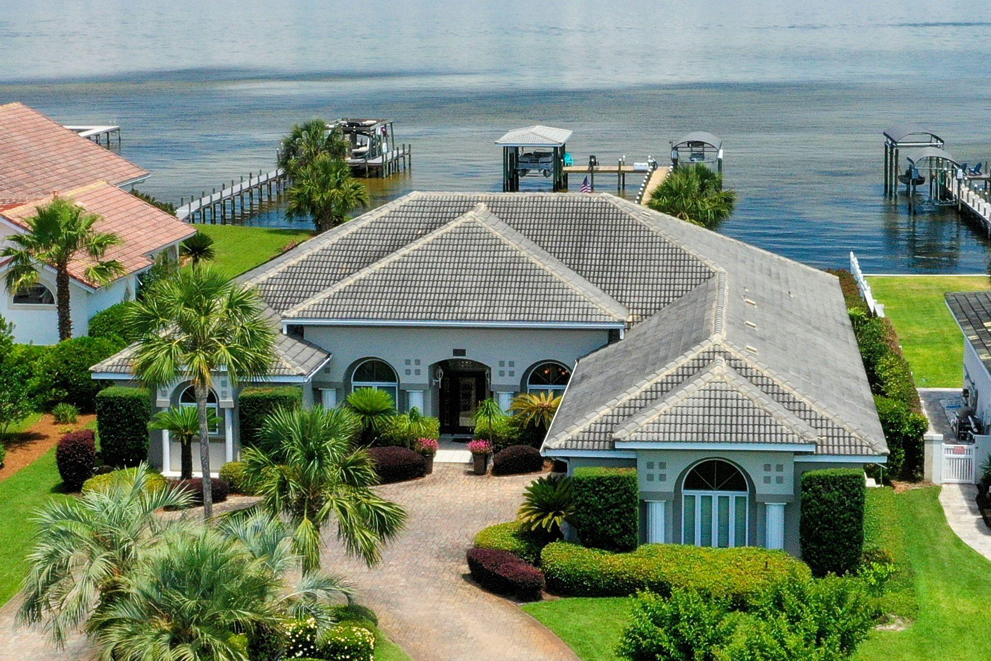 Wake up to beautiful mornings with endless sunrises and sunsets over looking the water from this beautiful waterfront home! Enjoy your coffee sitting around the sparkling pool listening to your favorite tunes on the surround sound.  There is nothing missing with this waterfront beauty in a wonderful gated golf course community! Sub-Zero Stainless Steel Refrigerator with a Dacor GAS Cook Top and Electric oven. The breakfast area over looks the pool and bay. The open family room has a great fireplace! A Salt Water Pool newly resurfaced and solar heated with a screened Lanai. Two new nice boat houses with lifts. The newly built dock is well lite with a large sunning area. Sprinkler system on well water. Seller taking back up offers on a contingency.