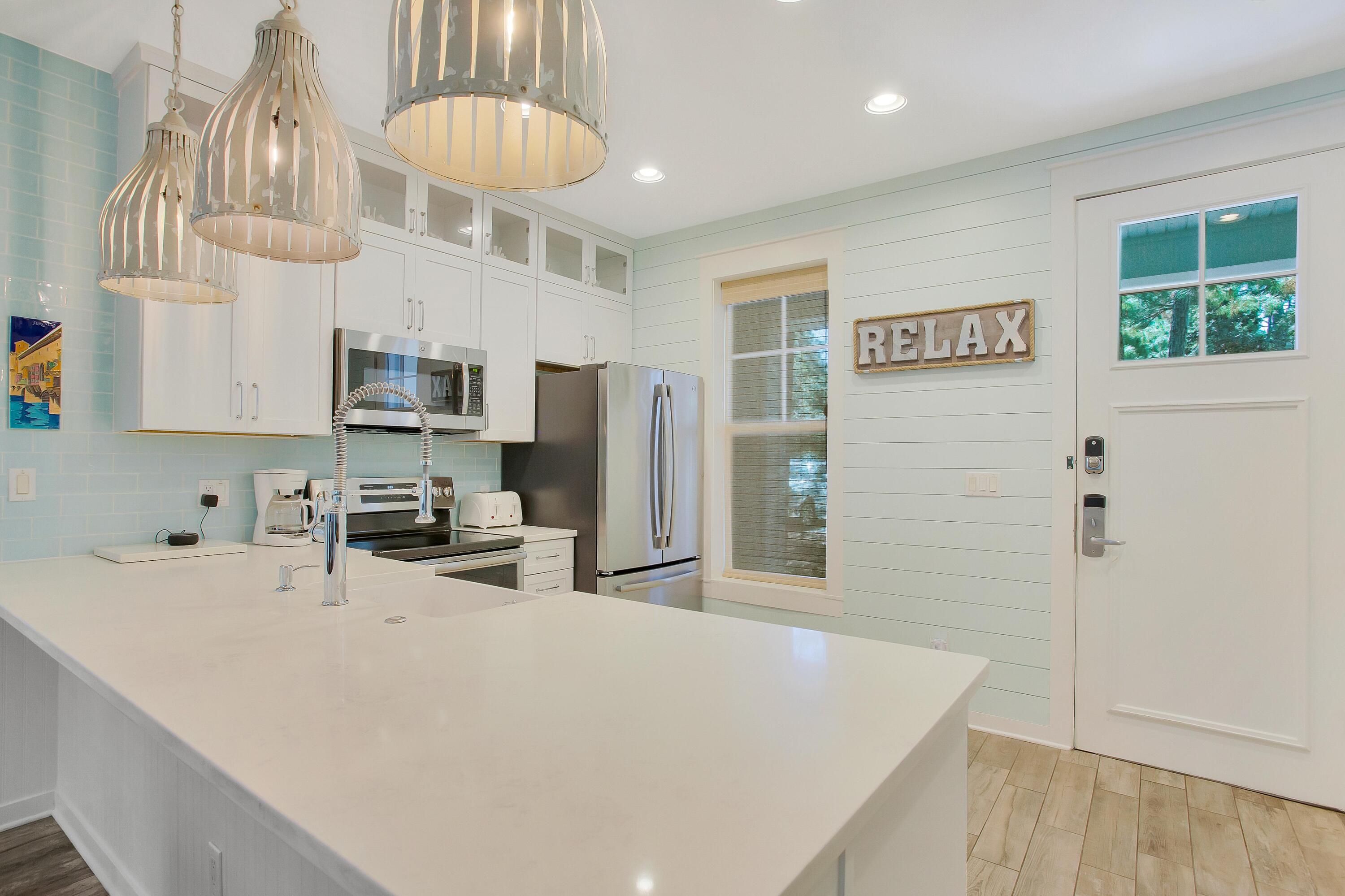 NEW 2023 ROOF, NEW 2023 WATER HEATER, NEW 2021 HVAC, AND FULLY REMODELED in 2018! This home has been grossing an average of $60k-70k annually and is already booking up in 2023. Tucked away on a corner lot, this fully renovated Florida Cottage is being sold furnished and turn-key, including the 6-seater golf cart. As you enter from the large wrap-around porch through the front door you are greeted with a pristine kitchen featuring, shiplap walls, quartzite countertops, stainless steel GE appliances, & unique lighting fixtures over the breakfast bar. Low maintenance wood look tile flows throughout the entire home. No carpet! The primary bedroom along with a guest suite are conveniently located on the main level while an additional guest bedroom and full bath are on the 2nd level.