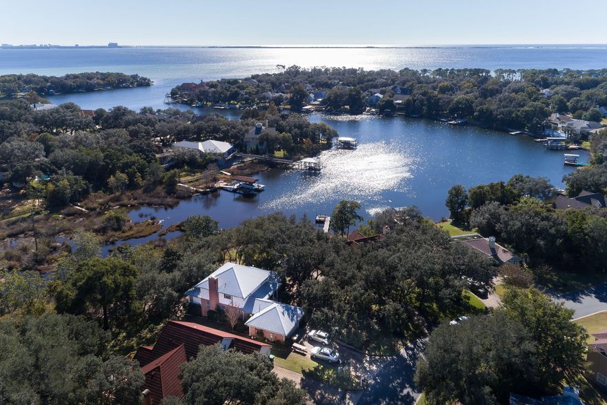 This is it! Beautiful water views without the waterfront price! 4 bedroom, 2.5 bath, large family home in the wonderful Shalimar neighborhood of Lake Pointe! Beautiful easy to care for home with water views from many rooms in the house. The wooded private front yard leads you to the welcoming front porch, into the spacious foyer with a beautiful stairway w/landing. From the foyer you can enter the private master bedroom (1st floor!) or back to the waterview dining & living rooms. The bright spacious kitchen and laundry room lead you to the garage. Likely, the favorite room of the home will be the cozy sun room. Enjoy a book & coffee there or outside on the spacious deck, nestled in the trees offering amazing views of ''Lake'' Lorraine and its relaxing sights and sounds.