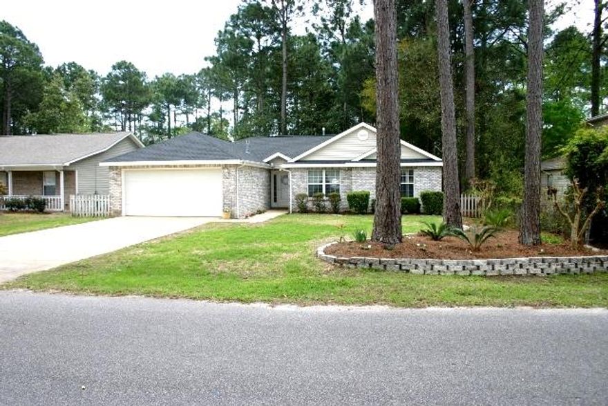 You must come see this charming home in Niceville! Just minutes from Eglin AFB, shopping, dining, the Niceville children's park, and beaches, the location is fantastic. You'll immediately warm to the cozy living area with natural sunlight filtering through the windows, gorgeous fireplace and hard wood floors. There's a dining area and family or bonus room just off the kitchen. The kitchen is complete with breakfast bar, matching appliances that include the refrigerator, dishwasher, stove, garbage disposal and built-in microwave. The master suite has a great walk-in closet, double vanities in the bathroom, new carpet and tile. There's actually new carpet in all the bedrooms! The owners have just had a new roof installed and you'll love the tree-lined view in the backyard. Plenty of places