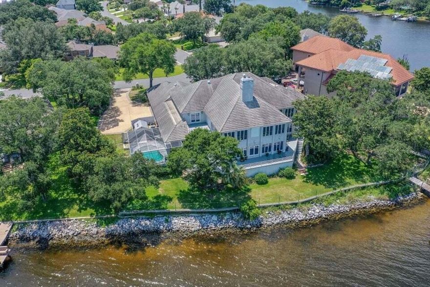 777 Boulevard of the Champions.  Welcome to your waterfront estate! Located on a double lot in the coveted Lake Pointe neighborhood with 180' of breathtaking waterfrontage, this magnificent residence is more than a place to live; it's a way of life! High and dry in the harbor of Lake Lorraine, with direct access to the bay, this home offers both safety and serenity! Upon entering, you'll be captivated by the sheer size and elegance of this home. Boasting five bedrooms and four and a half bathrooms, this residence offers ample space for family and guests. The primary suite is a sanctuary of its own, featuring serene water views, a private deck, and a luxurious en-suite bath with all the desired amenities.