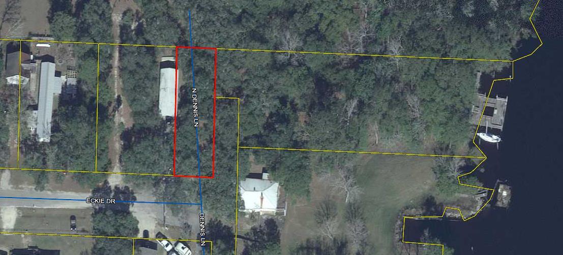 Lot on Dennis Lane with cement slab and covered storage.