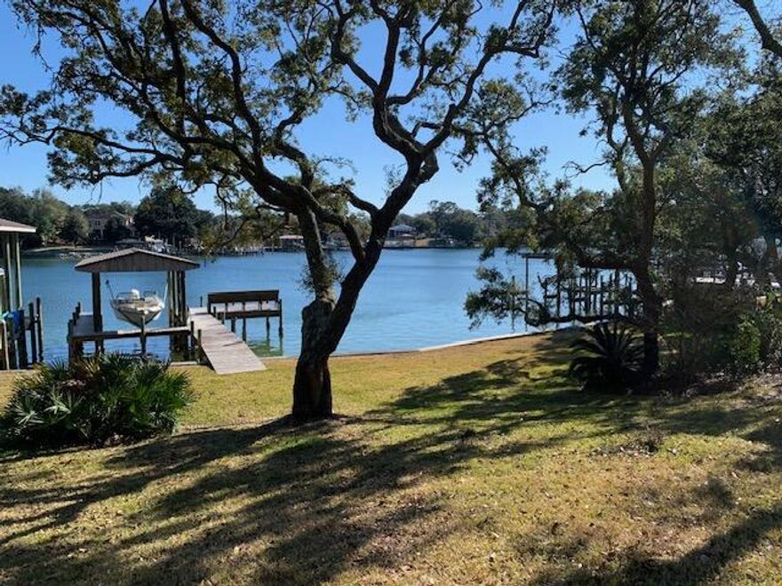 Amazing opportunity to own waterfront property on coveted Cinco Bayou.  This large property sits high and dry and has a dock with boat lift with deep water access.  Open concept floorplan features tile flooring, vaulted beamed ceiling and a split bedroom layout.  Kitchen has stainless steel appliances.  Huge utility/laundry room. Two car garage with paver driveway has an attached area for your golf cart or motorcycle. Spectacular grounds with mature landscaping has room to build a MIL suite if needed. Enjoy your morning coffee watching the dolphins, pelicans, eagles, ospreys, otters, etc  on decks overlooking the bayou.  Experience the waterfront life!