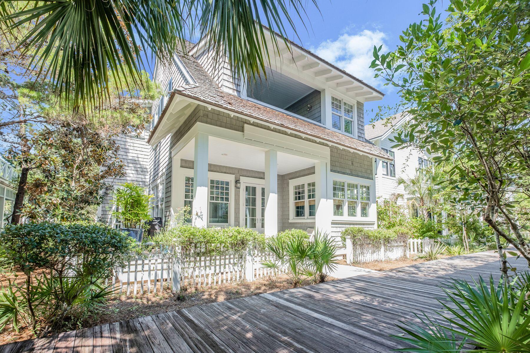 Displaying all the benefits of an extensive 2019 remodel, this luxury beach house enjoys a prime location. Backing onto a boardwalk, it's just seven homes back from the pristine sands of WaterSound Beach for morning dips and sunset strolls. Step onto the front porch where cushioned seats invite you to watch the world go by beyond the white picket fence. Inside there's a bright foyer and open great room with airy coffered ceiling. This spacious room is perfect for gatherings, vacations and celebrations. At other times, curl up on the sofa in front of the beautiful floor-to-ceiling stone fireplace with its wooden lintel and enjoy a more intimate ambiance. New bamboo flooring flows seamlessly through the formal dining area into the remodeled gourmet kitchen.