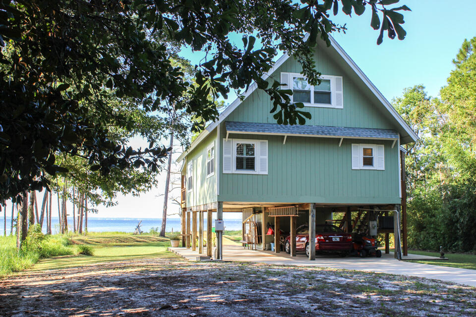 Welcome to this charming 3 bedroom, 2 bath home overlooking the Choctawhatchee Bay. The view encompasses the 331 bridge, Facing South offers breathtaking views from the Eastern sunrise to the Western Sunsets. This Bayside Beauty offers open concept living throughout the kitchen, dining & den where families & friends can gather after all day fun on the water. The choice of a primary bedroom could be main or 2nd level, offering a private balcony with again the most spectacular Bay views. Bedrooms are conveniently located to full bathrooms & offer plenty of light in the bedrooms. Covered parking for vehicles & golf cart, boat, kayaks & water gear. Covered Storage underneath.You are just minutes to fabulous restaurants like the The Bay & North Beach, Hammock Bays General store,Props Brewery