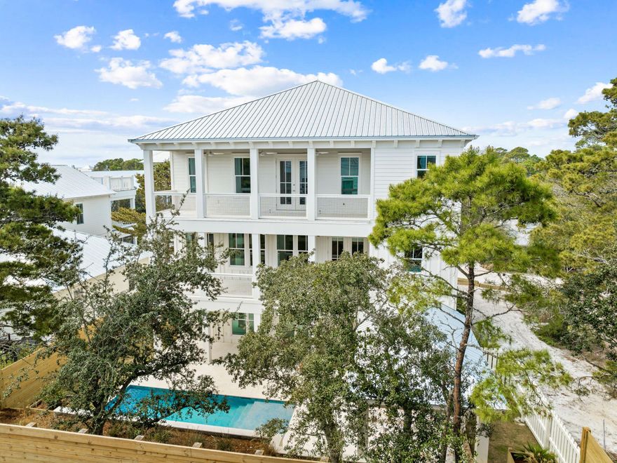 For those dreaming of a beach house beyond the ordinary, take a look at this brand-new, one-of-a-kind custom beauty.  Complete with designer wallpaper, feature lighting, handpicked artwork and high-end furnishings by local designer, Apres Sun,  it's quite unlike anything else on the market. Every space has been thoughtfully honed to combine European aesthetics with practical functionality. Rising from street level, this three-story home is fronted by a wide paved driveway and lawns edged with color-filled flower beds. A two-car garage accommodates vehicles, bikes and beach toys, while a covered porch frames the grand entrance. Explore the spacious pool room with sitting area, the laundry, bunk room and the pool bathroom on this level. On the second floor, wood flooring perfectly contrasts the light stone archway, which separates the dining area and the comfortable sitting room from the chef's kitchen. Imagine entertaining and memory-making with family and friends in this attractive space. A kitchen island provides seating for snacks and everyday mealtimes. White-washed walls, stainless steel appliances and veined quartz countertops enhance every inch of this enviable chef's domain. A butler's pantry and a custom hood over the range are just some of the added delights. A half bathroom and the first of two master suites complete this level. You'll want to check out the spacious walk-in closet and the stunning master bathroom with custom tile. 

The third-floor master suite is a peaceful sanctuary of tranquility. It includes a custom walk-in closet and a master bath with accent wallpaper above the twin vanity. The covered porch is perfect for enjoying private moments of relaxation at the start and end of each day. A cozy sitting area, laundry, and three additional bedrooms complete the generous accommodations. The loft is cleverly used as an additional TV area with a beverage refrigerator and bar for guests to help themselves to an array of drinks and snacks. Bathrooms have been individually designed using stylish tile and frameless glass shower doors. 

Outdoors, the rear fenced yard is centered on a contemporary heated pool complete with a tanning shelf and visual water jets. The pool view can be enjoyed from multiple balconies and outdoor relaxation areas. A lengthy covered gazebo provides the perfect place to unwind or dine with friends. For morning walks, stroll along the nearby white sandy beach and watch diving pelicans and playful dolphins in the beautiful gulf waters. Three beach access points and a nearby golf course create a retreat that's a coastal paradise beyond compare. Hop on bicycles, and in just four minutes, you can be browsing the shops and enjoying the live entertainment and restaurants at Gulf Place. Combining exceptional design with high-end finishes and a prime location, this unique residence provides a rare opportunity to experience 30A living at its very best. 