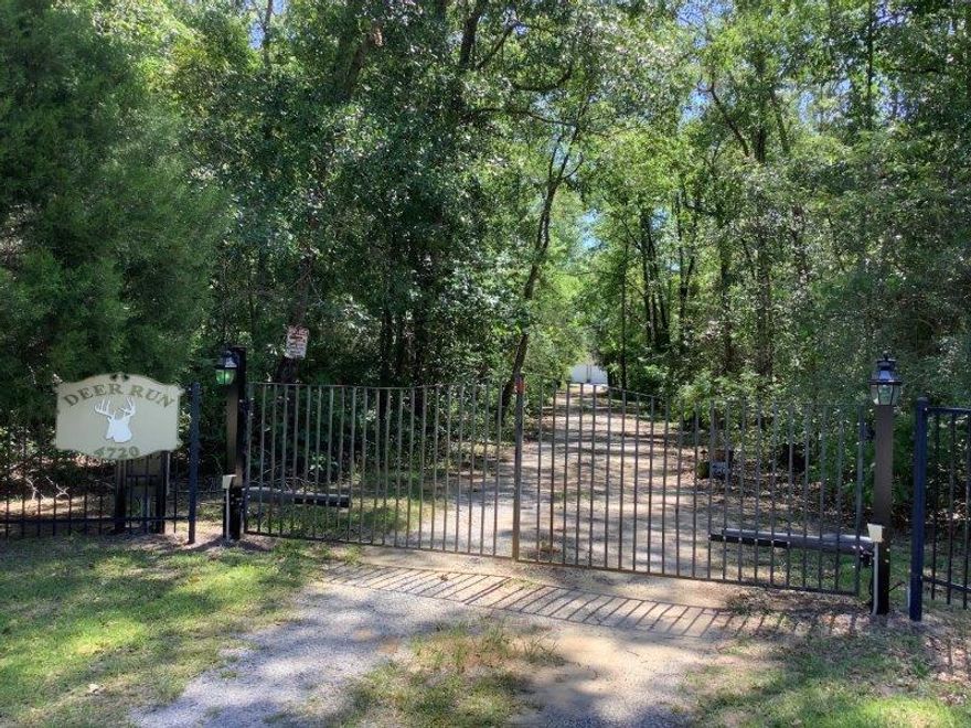 PRICE REDUCED AGAIN!!! Introducing 'DEER RUN', an incredible opportunity to own a gated, 21.5 acre private estate conveniently located near Interstate 10 and only 30-40 min drive to the Beaches of S Walton, the NW Florida Beaches Int'l Airport, and Panama City Beach. Many improvements include custom main house, 2 guest cottages, 2 large metal barns/workshops, a 'She Shed' storage/craft shop , small storage building + an RV shed with water & power. 2296 sq', 3 BR/2 BA's shown is for custom main house only-there is an additional BR & full bath totaling over1000 sq' heated & cooled area in guest cottages. Approximately 80% of large tract is naturall woodlands with predominately native hardwoods - all uplands in flood zone 'X' with hiking & riding trails throughout. Plenty of room to add a pond. Choctawhatchee River @ Sandy Creek Landing' is only 2.3 miles from this estate via River Road.  Property to convey 'AS-IS' .  Please contact list agent for appointment to view.