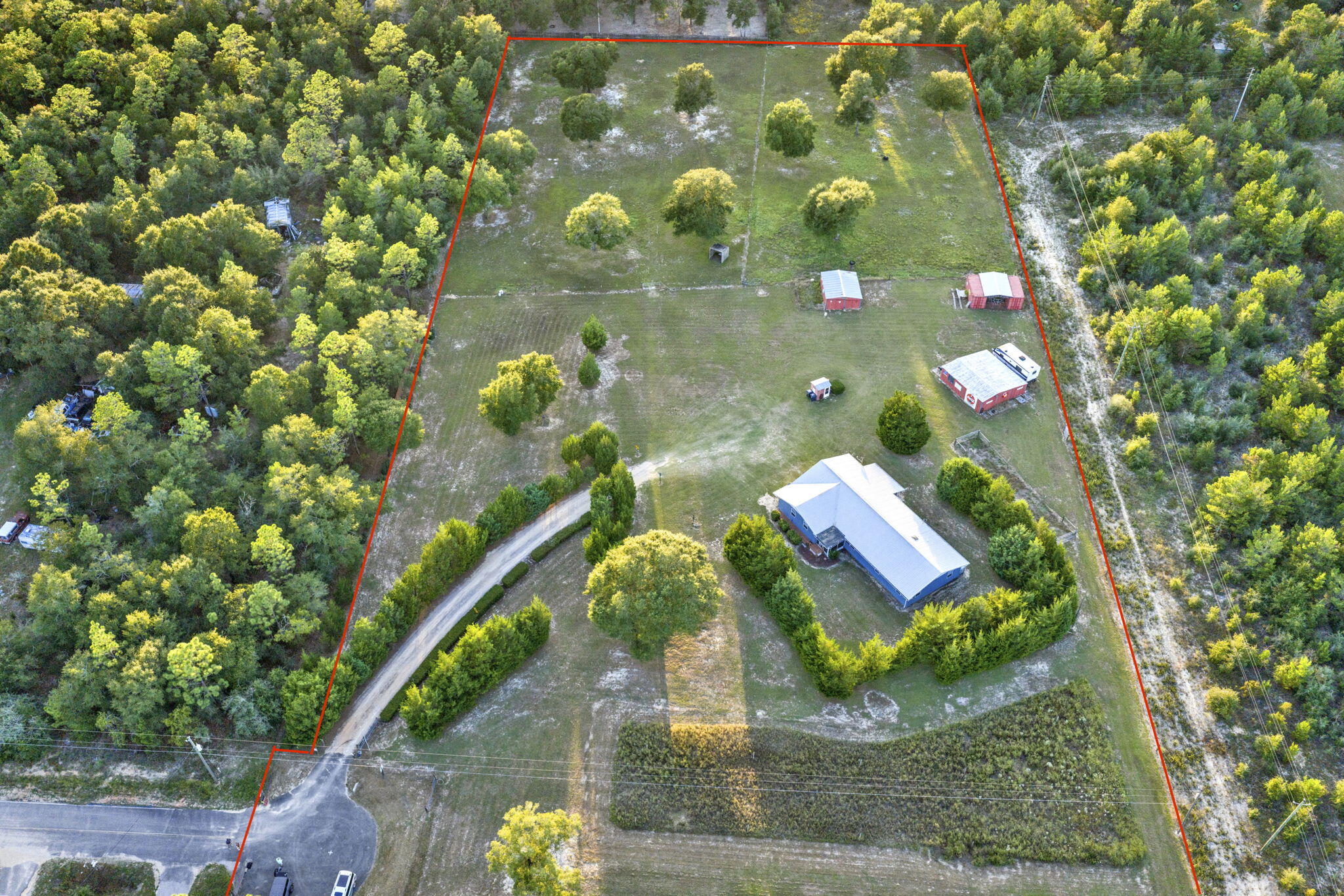 Welcome to your personal HOMESTEAD!! This 5 ACRE property is perfect for your quiet retreat or your farming and animal paradise! The property is FULLY FENCED with areas dedicated to PASTURES and GARDENS. The house is tucked neatly within mature CEDAR TREES and has a nice ramp to guide you to the SCREENED FRONT PORCH. As you enter the front door, you have a spacious FAMILY ROOM/DEN that gives access to the main LIVING AREA/DINING AREA full of natural light from the large windows. The KITCHEN is just off this area and has plenty of counter space including an enormous MOBILE ISLAND perfect for prepping food or entertaining. The hallway gives access to the INDOOR LAUNDRY ROOM, HALL BATH, AND ALL BEDROOMS. The MASTER BEDROOM AND BATH are tucked away in the very back of the hall and the ... ... bathroom has a large TILED WALK IN SHOWER. This house has multiple items needed for Handicapped individuals including a RAMP out front, consistent WOOD LAMINATE FLOORING throughout, GRAB BARS in the Master Bath Shower, and a working CHAIR LIFT in the garage. The SCREENED BACK PORCH allows you to sit and watch the garden grow and the animals graze. Along with a rabbit proof garden, there is a larger garden area with BUILT IN IRRIGATION off the side of the house. There is a TEE PAD with a NET for practicing your golf swing (because you know you need it). MULTIPLE OUTBUILDINGS make life easy with farm equipment and has a GARAGE DOOR OPENER for the tractor shed. Pastures have a HINGED GATE to allow movement from one pasture to the other with ease. The CHICKEN COOP HOUSE is one that any chicken would envy. Schedule your showing now and see all that this perfect property has to offer.