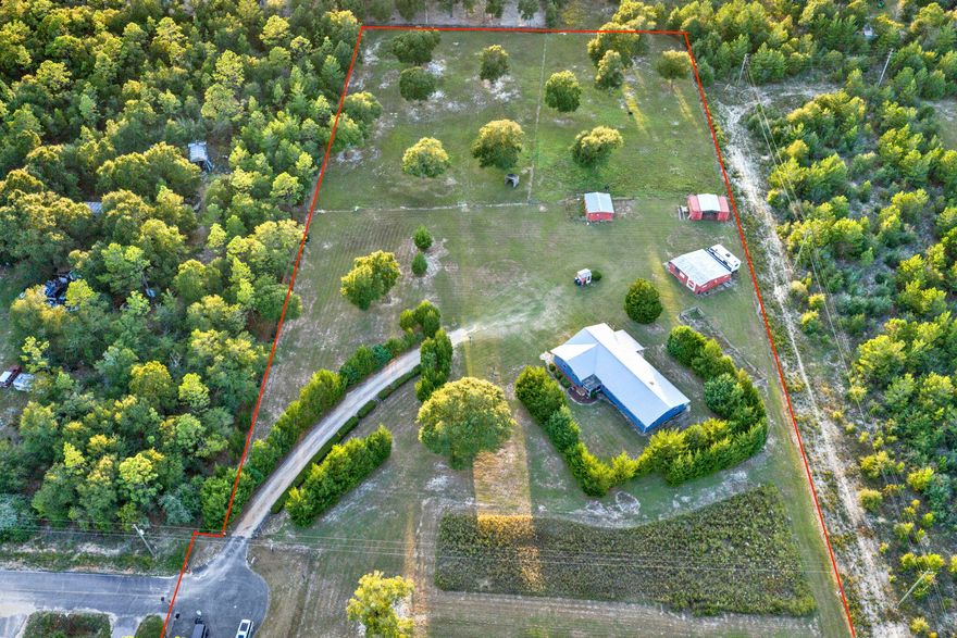 Welcome to your personal HOMESTEAD!! This 5 ACRE property is perfect for your quiet retreat or your farming and animal paradise! The property is FULLY FENCED with areas dedicated to PASTURES and GARDENS. The house is tucked neatly within mature CEDAR TREES and has a nice ramp to guide you to the SCREENED FRONT PORCH. As you enter the front door, you have a spacious FAMILY ROOM/DEN that gives access to the main LIVING AREA/DINING AREA full of natural light from the large windows. The KITCHEN is just off this area and has plenty of counter space including an enormous MOBILE ISLAND perfect for prepping food or entertaining. The hallway gives access to the INDOOR LAUNDRY ROOM, HALL BATH, AND ALL BEDROOMS. The MASTER BEDROOM AND BATH are tucked away in the very back of the hall and the ... ... bathroom has a large TILED WALK IN SHOWER. This house has multiple items needed for Handicapped individuals including a RAMP out front, consistent WOOD LAMINATE FLOORING throughout, GRAB BARS in the Master Bath Shower, and a working CHAIR LIFT in the garage. The SCREENED BACK PORCH allows you to sit and watch the garden grow and the animals graze. Along with a rabbit proof garden, there is a larger garden area with BUILT IN IRRIGATION off the side of the house. There is a TEE PAD with a NET for practicing your golf swing (because you know you need it). MULTIPLE OUTBUILDINGS make life easy with farm equipment and has a GARAGE DOOR OPENER for the tractor shed. Pastures have a HINGED GATE to allow movement from one pasture to the other with ease. The CHICKEN COOP HOUSE is one that any chicken would envy. Schedule your showing now and see all that this perfect property has to offer.