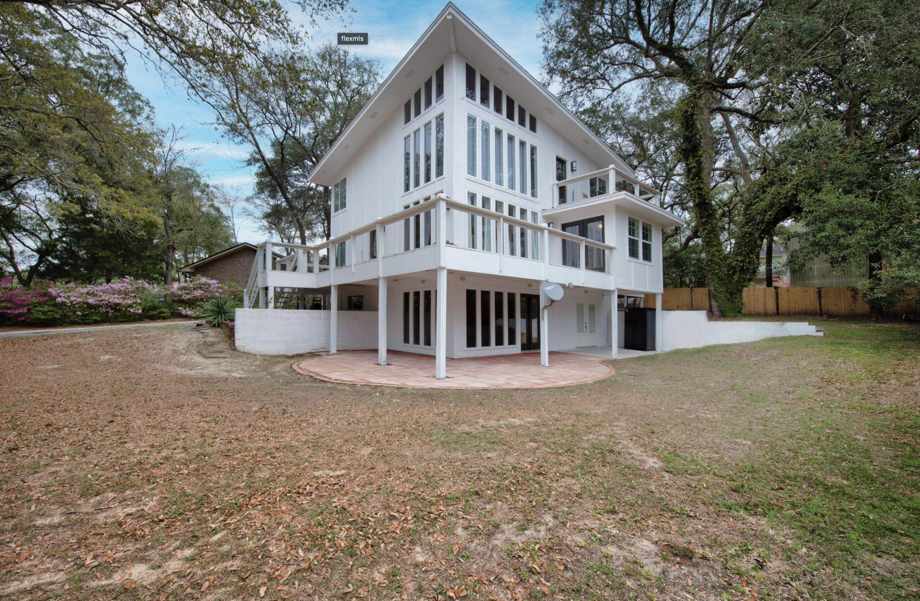 3.75% assumable mortgage to qualified buyers. This is quite possibly one of the most beautiful and uniquely designed homes in theNiceville area. Let all the Florida sunshine come in through the floor to ceiling windows and shine on the golden bamboo flooring (newer). Whetheryou enjoy entertaining guests or cooking for one, you will be pleased with the open concept kitchen with granite counter tops and an abundance ofcabinets. The siding is made of sturdy fiber cement siding and the home has multiple levels of balconies, decking and covered patios, surroundedby beautiful mature trees, peek-a-boo water views & fenced back yard with a large workshop. Bottom level has a separate entry that could possiblybe used as an apartment or in-laws quarters.
