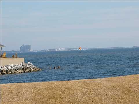 Beautiful light and bright second floor unit in a great Shalimar location with views of Shalimar Yacht Basin and a peek of Choctawhatchee Bay from the balcony. Large tile in the kitchen, living room, dining area and bathroom. Soaring ceiling at the entrance with a generous foyer area adjacent to the kitchen for maximum flexibility. Recent improvements include new laminate wood flooring in the bedroom and closets, new closet doors, new recessed lighting with dimmers in the living room, dining area and bedroom, new blinds at the entrance, additional electrical outlets, new door hardware and a new ceiling fan in the living room. The unit has also been freshly-painted with high-quality Williamsburg paint. Finisterra is a well-maintained complex overlooking Choctawhatchee Bay just minutes away