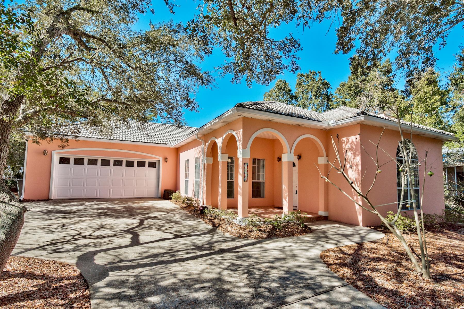 When you blend a little Mediterranean style with a touch of New Orleans and the color of Florida's coral seashells, you have this charming tile-roofed, stucco home framed by a white picket fence under a canopy of native trees. Best of all, Phase III Seabreeze allows short term rentals! The setting is inviting pulling into the shaded driveway and 2.5-car garage. A front covered patio sports four unique arches. Architectural interest inside includes Doric columns, gleaming tile floors, crown molding and a cozy tub next to a large glass block window. This home delivers on accessibility with one floor living, wider than average doorways, abundant shower handles and appropriate sink heights.