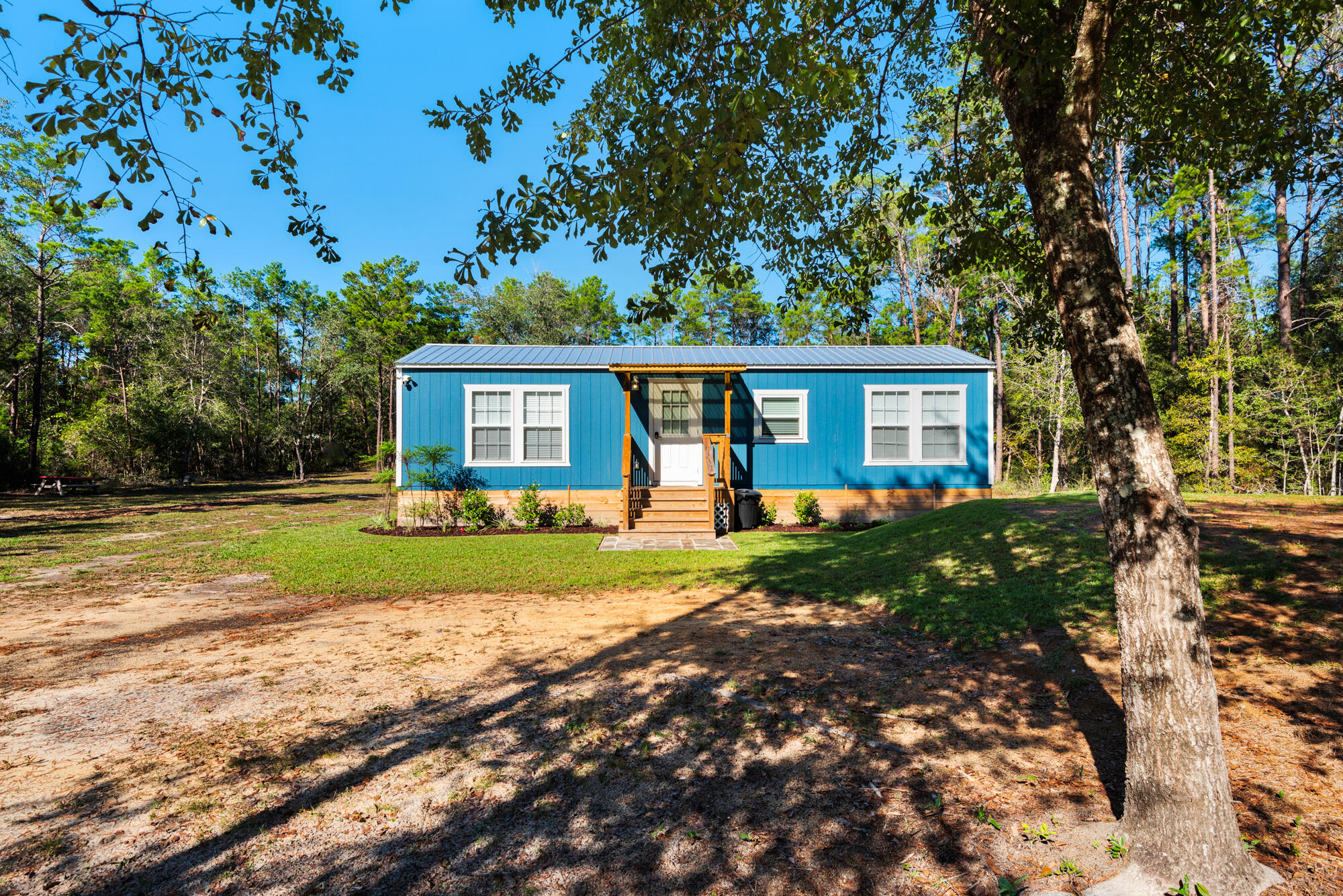 Newly constructed home nestled on over an acre of cleared land in the heart of Freeport. With utilities in place and a new septic system installed, this property offers ample room to expand--build a larger home or a second residence! This uniquely decorated home was operated as a successful short-term vacation rental with a strong rental history. Complete with hardwood floors throughout, a kitchen island, butcher block countertops, stainless steel appliances, and abundant cabinet space. This home is equipped with two ductless AC systems and hurricane proof windows. A large wood deck in the back and lovely front porch. This rare gem offers a blend of charm, functionality, and potential. Whether you're seeking a turnkey home or an investment opportunity, this property has it all.