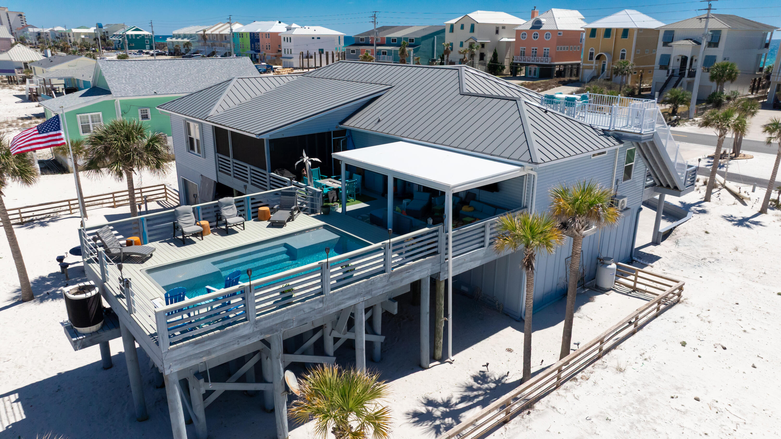 A Beach Home with coastal charm offers the perfect balance between relaxation and entertainment. Whether you're seeking full-time residence, vacation escape or an investment property, this home is sure to exceed your expectations. Wake up to the sound of waves, spend lazy days by the pool and end with sunset views from the 10 x12 crow's nest. This fully furnished and equipped home offers all that and more. 3 Bed/3 Baths plus a bonus rm and an office. Living and Den creates an inviting space with a gas fireplace and a 4-seat Bar with a wine cooler. Main areas flooring is ceramic plank tile. The Kitchen features dual powered range with 2 ovens, stainless appliances, oversized breakfast bar, abundance of Granite Counter space and custom soft close cabinets. The dining area includes a custom designed and built Beverage Bar with two coolers. There's an elevator from the ground floor/garage area to the living area above. Primary Suite has two walk-in closets, primary bath features a large walk-in shower with both rain and a handheld shower head. Bedroom 2 has its own door to the pool area and an ensuite bathroom. Bedroom 3 has its own slider door to the front deck plus offers a flexible bonus room which could be used as a 4th sleep area or office. Outdoor living and Entertaining areas offer Heated and Cooled Saltwater Pool with fountains and sun pads. The cover deck is equipped with remote-controlled clear plastic curtains for enjoyment regardless of the weather. Enter the covered and screened lanai through the pocket slider doors from the dining/kitchen. This home is equipped and ready for entertainment. There are 4 garages with parking for 3 vehicles and a golf cart perfect for exploring the island in style. There's a larger entertaining area under the house with its custom built-in seating, tables and undersea lighting and decor. Don't miss the opportunity to make this exceptional beach home yours. Contact us today to schedule a private showing and discover the ultimate coastal lifestyle.