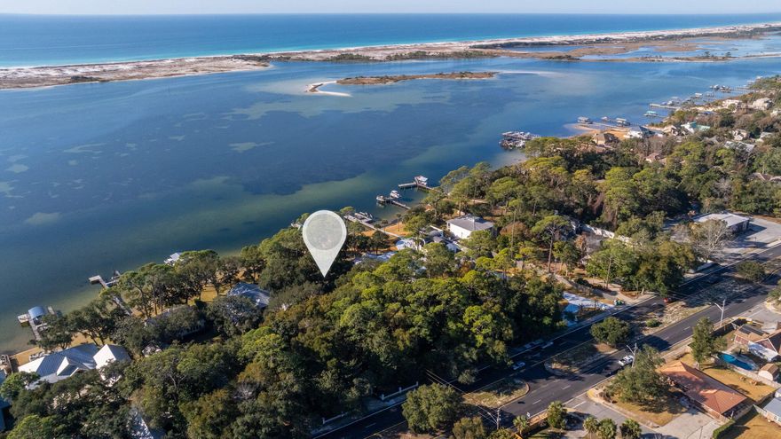 Discover a rare and breathtaking piece of waterfront property on Miracle Strip Parkway in the heart of Mary Esther overlooking the gorgeous Santa Rosa Sound. This exceptional estate sized lot is 0.89 acres and features 101 feet of water frontage while being nearly 400 feet deep. This gorgeous lot offers tremendous potential to either renovate and breathe new life into an older home or for redevelopment. It can be subdivided into two parcels per the city once the home/structure is removed. It can either be subdivided into two waterfront lots or as one waterfront and one dry lot. Nestled among majestic old oak trees, towering pines, and fragrant magnolias, this ultra-private setting provides a serene retreat with stunning sunrises and sunsets over the water. The white sandy natural shoreline features sea oats and grasses and offers a beautiful backdrop along the deep blue waters of the Intracoastal waterway. Whether you envision an exclusive estate, a multi-home development, or an investment opportunity, this property offers endless possibilities in an unbeatable location.  Don't miss this chance to own a legacy waterfront property with unparalleled beauty.