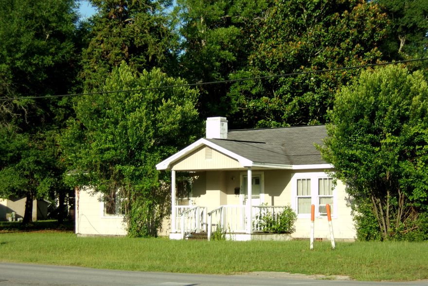 In the heart of town, Older home in need of alot of TLC~ 3 bedrooms, 2 baths~  Living room, dining room, utility room and one bedroom has hardwood floors~  Most of the walls have paneling~  Fireplace in the living room~ There are a total of 4 lots ~  Right across the street from Northwood Elementary~  Being sold AS IS~