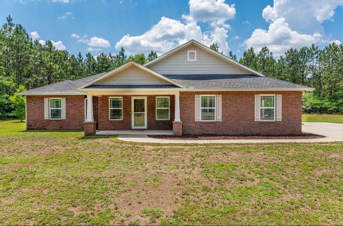 Laurel Hill Hidden Gem! This custom-built, fully brick 3BR/2BA home sits on 8.6 private acres, tucked away and unseen from the road. Built in 2018 with high-end finishes and stainless steel appliances, this home offers exceptional quality and style. Enjoy the peaceful screened-in back porch, spacious shop, extra portable building, and a chicken coop--perfect for starting your own mini-farm or homestead. Just 45 minutes to Destin beaches, this rare property blends upscale living with country charm.