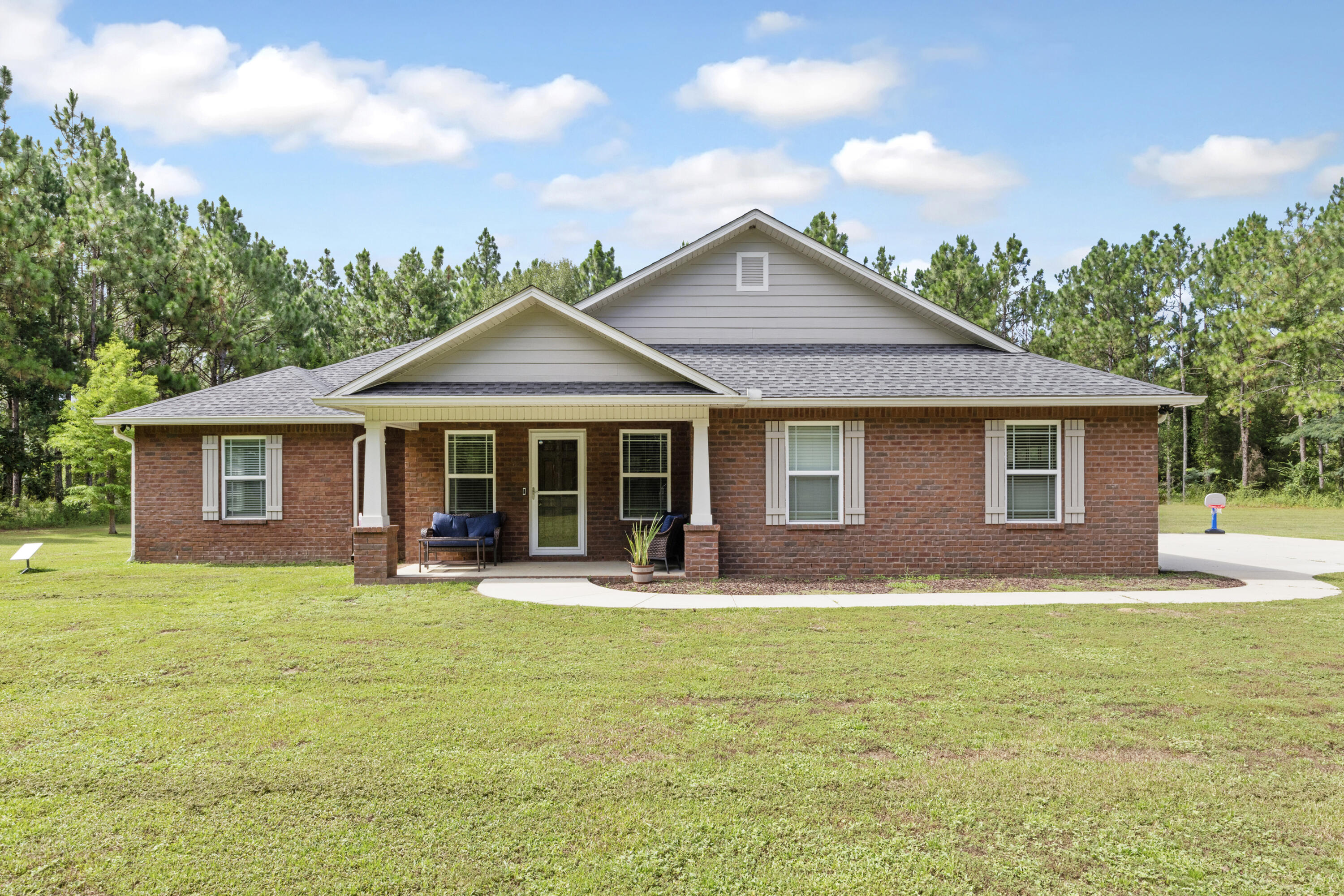 This home was custom built in 2018 with quality and comfort in mind. The fenced acreage includes cleared perimeter trails--ideal for ATVs, dirt bikes, or peaceful walks through nature. The 24x36 detached garage/shop is perfect for storing equipment, working on projects, or even converting into additional hobby space. The 12x20 yard building adds extra storage. Enjoy quiet mornings on the screened back porch or entertain guests on the adjacent concrete pad. Inside, you'll find smooth ceilings, tile wood-look flooring throughout, and a bright open-concept layout. The home is prewired for surround sound in the living room, and spray foam insulation helps with energy efficiency. Pecan trees are scattered across the property, and 14 yards of crushed asphalt have been added for potential future improvements. A recently built chicken coop has also been added, making a great location for those aspiring to own a mini farm. This is country living at its finest. private, peaceful, and still conveniently located.