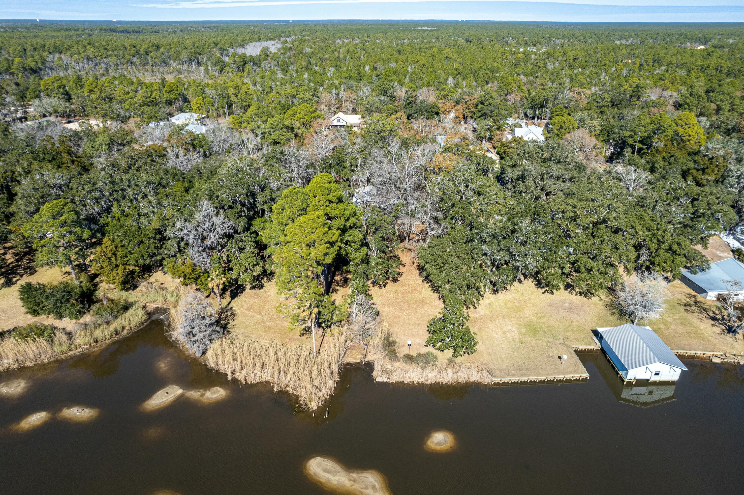 Welcome to this unique Bayfront property, offering breathtaking water views and the serene beauty of nature, all set against a backdrop of majestic, mature trees. This charming home presents an incredible opportunity for the right buyer to unlock its full potential.Nestled along the shoreline, 443 Pitts Bayshore Drive provides a rare chance to create your dream home with direct access to the water and endless possibilities for customization. The home sits on over an acre, with California Redwood on both the exterior and interior, as well as knotty cypress in the main living area. With three bedrooms, plus an office or flex space, three bathrooms, several covered porches, and an additional kitchenette downstairs, a quiet bayview respite is just steps away.Many charming features of  this home are ready to be restored and enhanced, while the sprawling yard offers plenty of space for outdoor entertaining or creating your own waterfront retreat. View the sparkling bay waters and wildlife from a breezy canopy of hickory, oak, and magnolia trees. Boating enthusiasts enjoy direct access to the water, as an upland cut is already in place to re-build a dock.
Located just 3.8 miles from the 331 bridge, this home is ideal for buyers with a vision and a passion for waterfront living. Whether you're looking for a full renovation project or a weekend getaway, the location, the land, and the views are all ready to be transformed into your own custom bayfront sanctuary.
