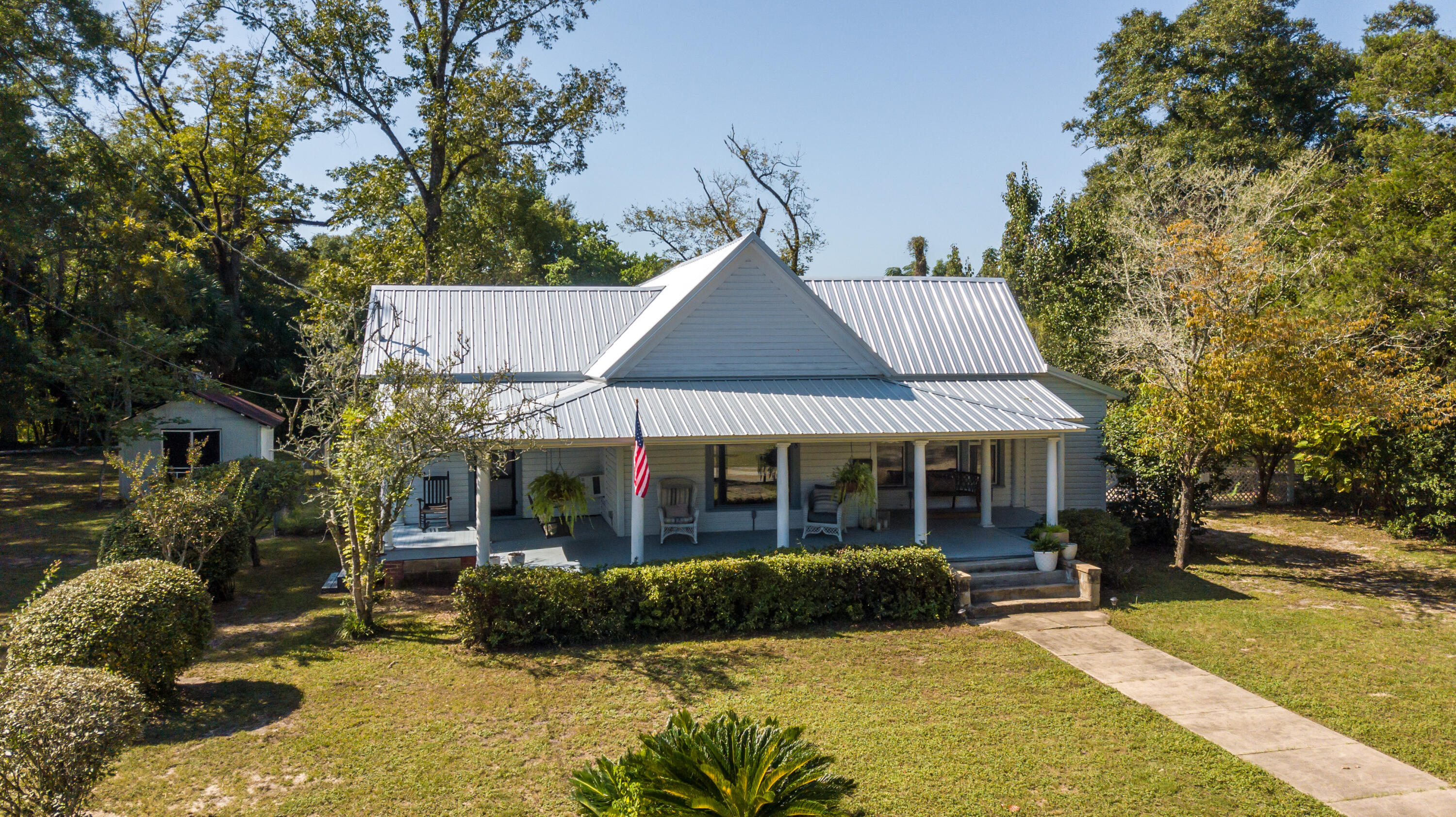 A lovely piece of 1930 DeFuniak history just blocks/walking distance from Lake DeFuniak and all vibrant downtown has to offer! The heavy lifting has been done: new metal roof, new electrical/wiring, new plumbing and newer paint inside and out. Some of the original hardwood floors,''punch'' light switches, and architectural details like oversized baseboards & high ceilings, some tongue-and-groove, showcase a time gone by. The front porch alone is swoon-worthy. Large rooms that can serve multi-purposes throughout. The master has a large sitting room that could be ideal for a nursery, home office, etc. The main updated bathroom is sizable with a striking wallpaper design. Zoned R2, with room to add a dwelling for family or a rental to offset a mortgage. This is a find at this price point!