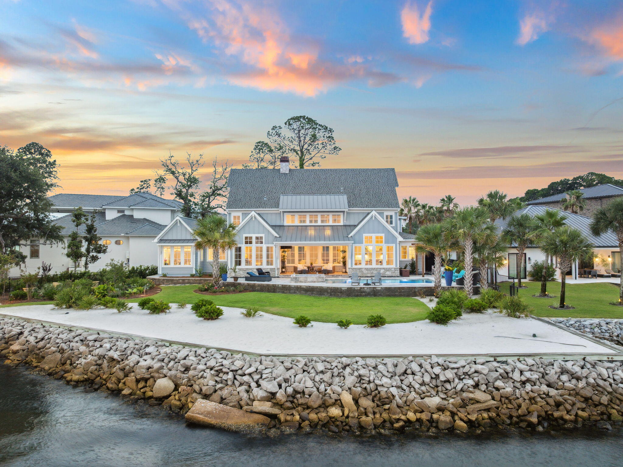 37 Driftwood Court is a Watersound-inspired mansion tucked in the center of a quiet, five-home cul-de-sac and offers the kind of privacy that's hard to come by in this area - while still being just minutes from Grand Boulevard, Topsail State Park, and Scenic Highway 30A. The home greets you with a floorplan that opens up immediately: 20-foot ceilings in the great room are framed by floor-to-ceiling windows that flood the home with natural light, waterviews, and sunsets along the Choctawhachee Bay. The layout was made for hosting and the uniquely wide lot creates a floor plan that sprawls & gives each space a sense definition & flow. The open-concept main level comfortably accommodates up to 40 guests, and the kitchen sits right at the heart of it all, as any good kitchen should.