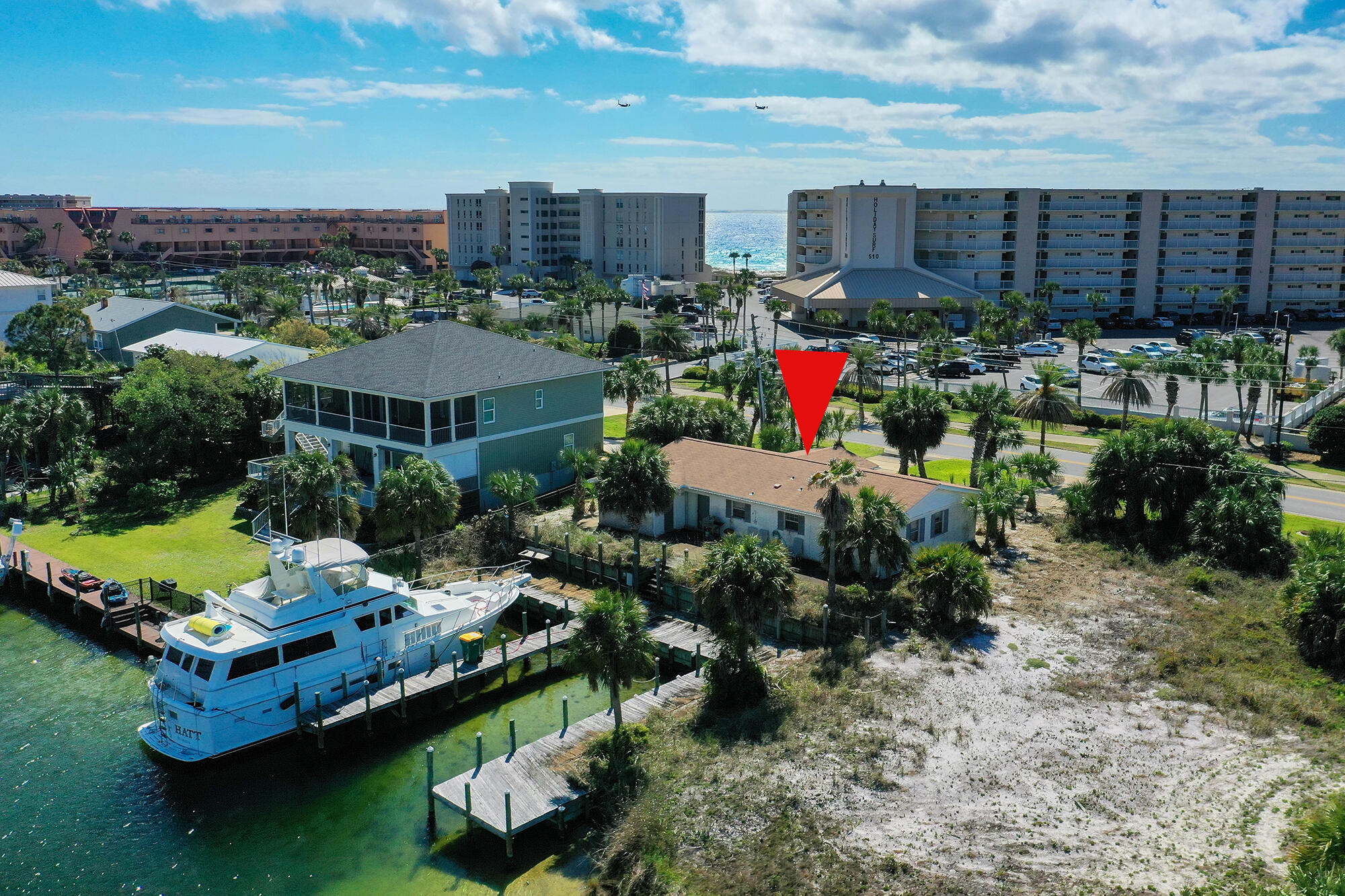 Holiday Isle Lot with two wide large Boat Slips. House sold AS-IS and docks need upgrade. Perfect location for anyone looking to build their dream home across from the beach, with boat slips, fast access to the Gulf, and beautiful views in all directions, including the Gulf, Harbor, and Canals. One of, if not currently the only, re-buildable lots available with large slips.
