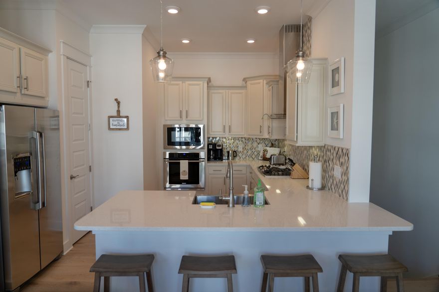 Coastal chic meets beach elegance at this charming 2B/2B townhome with one car garage in the popular community of Prominence on 30A. Spacious chef's kitchen overlooks living and dining area. Equipped with all the latest builder upgrades including a gas cooktop, oversized fridge, stainless appliances, farmhouse sink and soft close cabinetry. Open living and dining areas have 10' ceilings and expansive windows. Two sets of French doors lead to covered deck overlooking neighborhood. Ideal two bedroom layout boasts king-sized master bedroom with ensuite, large walk-in closet, dual sinks, oversized shower and upgraded fixtures. Guest bedroom is well-appointed with set of French doors leading to the balcony and tub/shower combo with convenient hall access. Laundry room includes full-size washer/dryer. With resort-style amenities, convenient location across from eateries and shopping at the popular Hub and a short bike, shuttle or car ride to the beach, this coastal charmer offers the best of everything that's great about 30A.