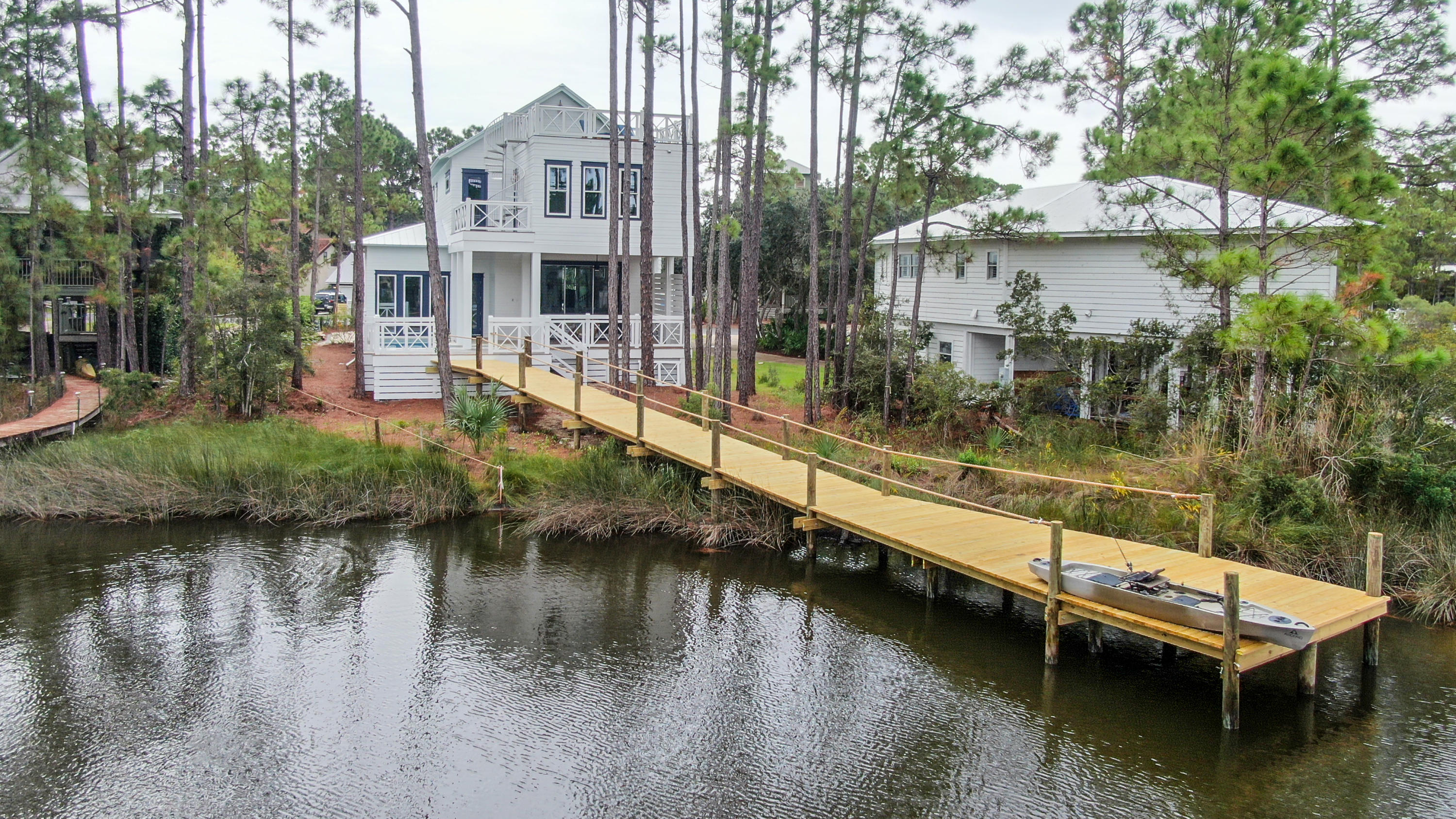 The perfect blend of classic beachfront and upscale sophistication in this custom 5-bedroom, 4.5 bath home presents a unique opportunity to fall in love with 30A all over again. From the dock overlooking the Coastal Dune Lake to the open flow of the living spaces throughout, you will be intoxicated by the allure of this seaside retreat.Greeted by a beautiful foyer with high ceilings and stunning staircase, the hardwood floor leads you through the family room to a wall of windows out to the pool deck, and down your private dock to the rare coastal dune lake. The gourmet kitchen offers an oversized island, custom cabinetry and a suite of appliances, perfect for entertaining or large family gatherings.Every level of the home full advantage of the natural surroundings, embracing