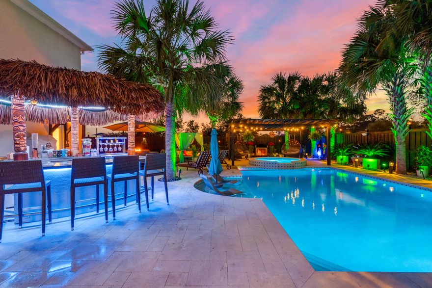 ** Architectural Masterpiece with Carriage House and Heated Saltwater Pool & Spa ** Step into a world of outdoor elegance and entertainment with this stunning property. The backyard is a true paradise, featuring a private heated saltwater pool complete with a sun shelf and a soothing waterfall spa, all framed by a stylish pergola. Surrounded by beautifully landscaped gardens filled with vibrant flowers, lush plants, fragrant citrus trees, and the shade of palm, this outdoor space is both serene and inviting. Natural shell stone pavers elegantly encircle the pool and outdoor area, leading you to an impressive outdoor granite kitchen equipped with an ice chest, fridge, grill, sink, and cooktop--ideal for alfresco dining and entertaining guests. Gather around the lighted tiki bar, complete with a sound system, TV, ice chest, two mini fridges, and a wine rack for your enjoyment. The full bathroom conveniently located by the pool ensures that your guests can refresh without having to enter the main house. Relax under the large covered patio and enjoy the enchanting ambiance created by color-changing lights surrounding the pool and throughout the outdoor entertainment area. The pool and spa are heated with natural gas and fully automated via the Pentair app, allowing you to enjoy a perfect swim at any time. 

Stepping inside, the main house offers an exquisite blend of luxury and comfort. This meticulously designed residence features 3 spacious bedrooms and 2.5 baths, including a master suite with a jet tub equipped with speakers and ambient lighting, creating a spa-like retreat. Both bathrooms are enhanced with double vanities, providing ample space for daily routines. 

The executive office, complete with built-in workspaces and lighted shelving for decor, creates an ideal environment for productivity. Architectural details such as columns, arches, and board & batten accents add sophistication throughout the home. The chef's kitchen is a dream, featuring tile flooring, a built-in 5-burner gas cooktop, and stunning granite countertops, all flowing seamlessly into the living areas adorned with hardwood floors. 

Enjoy peace of mind with a full house automated Fantech ventilation and air filtration system, ensuring a continuous flow of clean, fresh air. Additional features include storm windows and doors, plantation shutters, a durable metal roof, and energy-efficient spray foam insulation. 

For added convenience, the property includes a 2-car garage with a thoughtfully designed carriage house above, which features a stair lift for easy access. The carriage house offers a cozy bedroom, a full bath with a luxurious waterfall spa shower complete with 8 jets, a kitchen with new stainless steel appliances, and a comfortable living room that opens to an expansive deckperfect for hosting family and friends. 

This luxurious property is a rare find, offering an unparalleled lifestyle of comfort, elegance, and entertainment. Don't miss your chance to make this exquisite home your ownschedule a private showing today!
