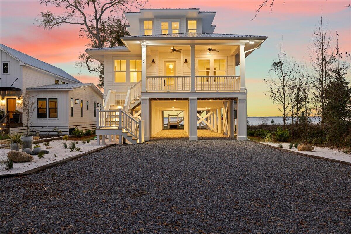 Welcome to 115 Native Tree--where classic Florida cottage charm meets modern sophistication. Perched on pilings in a nod to Old Florida's timeless design, this home is elevated to capture breathtaking bay views while offering future possibilities for its new owners. Whether you envision a garage, additional parking, or racks for your surfboards and paddleboards, the raised foundation provides flexibility for your coastal lifestyle or just enjoy the stunning bay views.  Inside, the warmth of white oak flooring flows throughout, leading you to an open-concept living space where the custom designer kitchen with Thor appliances overlooks the bay and seamlessly connects to an expansive rear porch--perfect for taking in those iconic waterfront sunsets.With four bedrooms and four baths this home exudes effortless style, infused with a subtle Australian-inspired flair. The custom all-oak staircase is a true masterpiece, anchoring the home's impeccable craftsmanship. Every bathroom features designer tile and quartz countertops, creating a luxurious yet inviting atmosphere.

Every detail has been thoughtfully curated, from the professionally landscaped grounds to the lighted steps and irrigation system. 115 Native Tree is more than a homeit's a work of art designed for those who appreciate classic beauty with modern comfort.

For a private tour, contact the listing agent today. 

