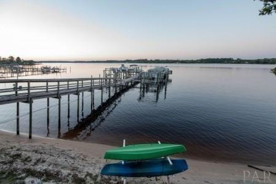 Unique waterfront find! 3-story townhouse on East Bay. Stunning water views from all three levels. 3 bedroom, 3 Bath home has private access to dock and swimming pool. High ceilings, crown molding and travertine tile floors throughout first level and all baths. Granite counters in the kitchen with stainless appliances . Upgraded soft close cabinets. Bedroom and full bath located on first floor. MBR has balcony over looking the bay. MBath has granite double vanity, walk in tiled shower and large jetted tub. Additional bedroom on second level with private bath. 3rd-level loft with built-in wet bar and opens up to a large deck overlooking the water. Only a 10 min drive to the beach! These units don't last long on the market! ***Please note: Pictures are not actual unit but similar layout**