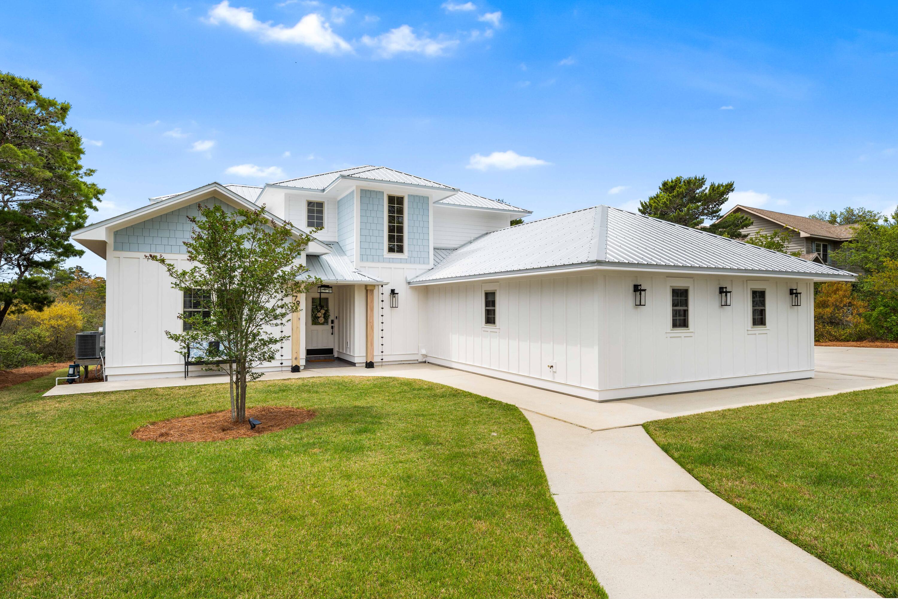 Positioned on a half-acre lot, this prominent home features tremendous curb appeal and a wonderful location in Blue Mountain Beach. This gorgeous four bedroom residence showcases a massive front yard as well as a long driveway leading to an oversized two-car garage. The enormous backyard is enhanced with a comfortable patio and has the potential for adding a private pool. Inside, the home displays a perfect layout with two separate living rooms, an updated kitchen, two dining areas, & the primary suite all located on the first floor. Upstairs, you have 3 bedrooms & 2 full bathrooms. The home has gorgeous windows allowing for an array of natural light to pour in. The main living room has breathtaking vaulted ceilings serving as an unforgettable gathering space. The oversized two-car garage comes equipped with a lockable storage room running the full length of the garage. The property has smart home capabilities, solid wood doors and excellent indoor storage areas. The exterior has been upgraded with a new metal roof, new hardy board siding, new paint, new gutters, new front door pillars & new light fixtures in 2025. Surrounded by luxury homes, 79 West Blue Coral Drive can become your next full-time residence, second home or vacation rental investment property. This stunning home is situated on a quiet street with no HOA and walkable to restaurants, beaches, & shopping. Only a 5 minute golf cart ride from the beach, 5 minutes from downtown Gulf Place and 10 minutes from Grayton Beach, this property offers both convenience and tranquility. Set up a private showing today!