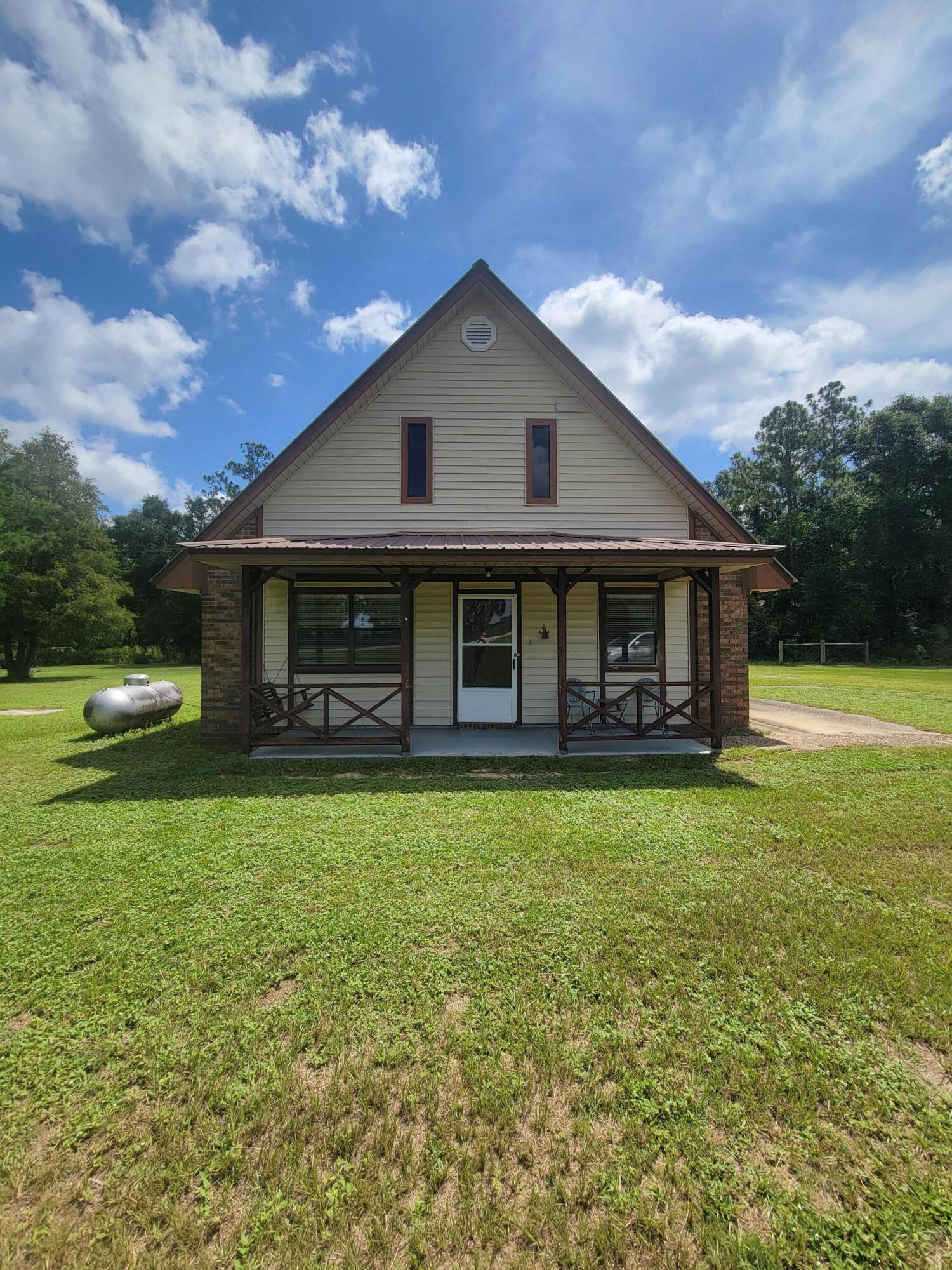 Country style brick A-frame home with metal roof on 2.5 acres. This property has 700' road frontage on Hwy 331 N, with the back section fenced. Home also has a RV hook-up. The 30' x 40' workshop and with carport, all with concrete flooring, water and electric. Has city water and septic tank, with RV Hook-up. The back of the house has a concrete patio area for grilling and relaxing. Interior of the home has cute space saver kitchen and up stairs master bedroom and 1/2 bath with the two bedrooms and a full hall bath down stairs w/lots of storage areas. The mobile home on the property not included. It has its own septic tank and city tap. Property is zoned Rural Village. Single wide mobile home will be removed in Dec. 2024.
