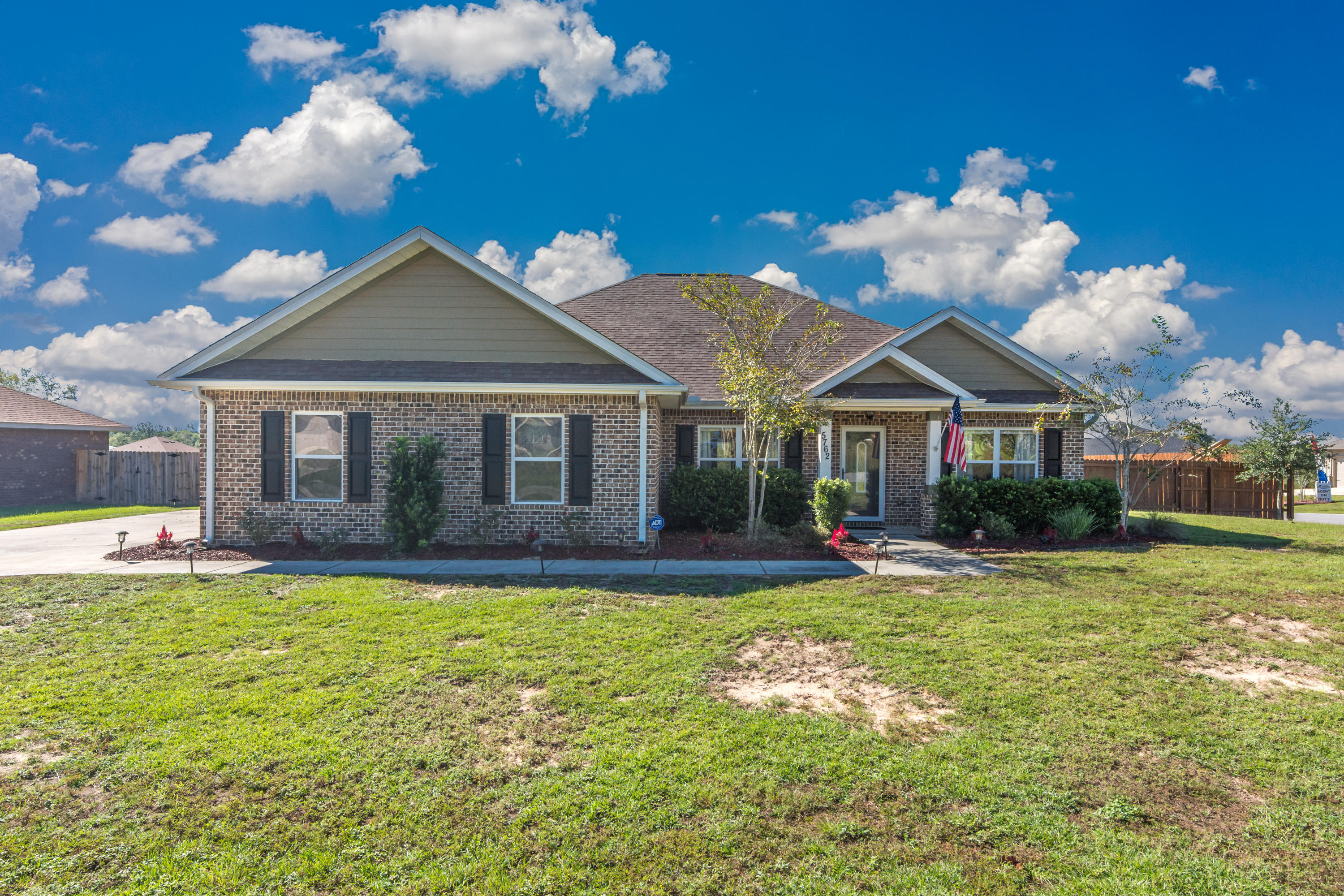 Welcome home! This home stuns as soon as you pull into the driveway. It doesn't end there! Walking in, you're greeted by beautiful tile and hardwood flooring throughout the spacious living area, a formal dining or bonus room, and a completely open concept living space. The chef's kitchen features stainless steel appliances, a huge central island, and custom cabinets and countertops. A well-appointed master bedroom is toward the back of the house, and the master bathroom is a welcome retreat with a walk-in shower, garden tub, amazing walk-in closet, and it has personality galore with ship lap surround. A split bedroom floorplan provides privacy, and a shiplap wall in a spare bedroom adds character. The yard is built for entertaining! The seller extended the covered patio so it's perfect for