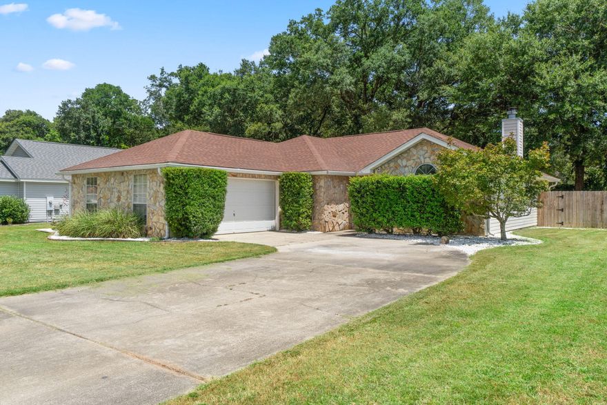 This great home is nestled at the end of a dead end street which provides a quiet, low traffic atmosphere. Located only 20 minutes from Downtown Pensacola and only 30 minutes to the white sandy beaches and emerald waters of Pensacola Beach.  One of my favorite things about this home is it's large backyard which features  a cover patio, fire pit with seating area, and best of all, a large section outfitted with rubber mulch which makes for a great play area for the kids.  The interior of the home is also just as amazing.  Once you enter the home, off the foyer is a large living room with vaulted ceilings and a fireplace.  Just past the living room is the large kitchen and dining area overlooking the backyard.
