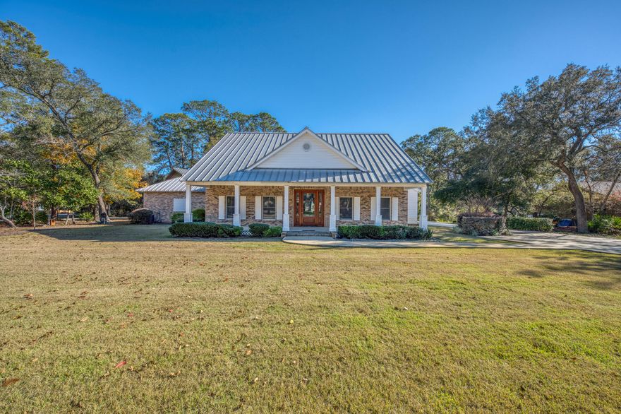 Set along tranquil bayou waters with 44 feet of frontage, this distinctive 3-bedroom, 2.5-bath estate offers 3,502 square feet of thoughtfully designed living space that blends character, functionality, and natural beauty. The main residence features rich wood flooring throughout, a welcoming fireplace, and a spacious first-floor primary suite that provides privacy and convenience. A durable metal roof enhances both longevity and architectural appeal.Two expansive covered porches create inviting spaces for outdoor relaxation and entertaining, overlooking the peaceful waterfront setting. A carport adds everyday convenience, while the detached two-car garage expands the property's versatility. Above the garage, a generous 21x27 finished living/workspace offers endless possibilities, ideal for a home office, creative studio, guest suite, or private retreat.

Designed to embrace its waterfront surroundings, this property delivers a rare combination of refined interior spaces, flexible auxiliary living areas, and tranquil bayou frontage, creating an exceptional opportunity for those seeking both comfort and lifestyle.