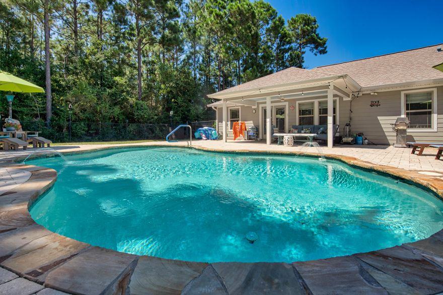 Welcome to 8169 Tavira Street--a beautifully maintained pool home on .5 an acre in the heart of Navarre that's made for entertaining, relaxing, and everything in between. From the moment you step inside, you'll notice the thoughtful upgrades throughout, including a whole-home Control4 smart system, with TV, that puts comfort and convenience right at your fingertips, as well as surround sound to play different stations in each of 4 areas: Pool/patio, back bedroom, living room and owner's bathroom. Make sure to look down, the virtually indestructible wood look porcelain tile are featured the main part of the home.The kitchen is a chef's dream with tons of counter space, generous storage, and a smart layout that makes cooking and hosting a breeze. The open flow invites gatherings big and small, and when the party moves outside your guests will love the sparkling pool, covered patio and lovely paver stones - perfect for BBQs, lounging, or cozy evenings under the stars. 
The massive owner's suite feels like a true retreat, featuring tray ceiling, upgraded dual vanities, a spacious walk-in shower, and a closet so large (and outfitted with custom built-ins) it could double as a small bedroom. Seriouslybring your shoe collection, it's got room.

The backyard is the cherry on top, an oasis of privacy with plenty of room to play and unwind. The back 50ft of the lot remains natural and uncleared, giving you peace, privacy, and endless birdwatching with no backyard neighbors. The pool comes with a vacuum, heater and there are 3 pool storage bins that are available to the next owner. The gas grill is ready for all the hot dogs and hamburgers you can cook with a limitless supply of gas, you'll never have to fill another propane tank, because it's hooked up to the home's gas lines. 

Don't worry the rest of the home is just as spacious. It's split floorplan not only provides privacy but tons of natural light! The home also comes with hurricane protection, and is wired for a security system. All of this, just minutes from Navarre Beach, shopping, and restaurantsso you're never far from fun, sun, and convenience.