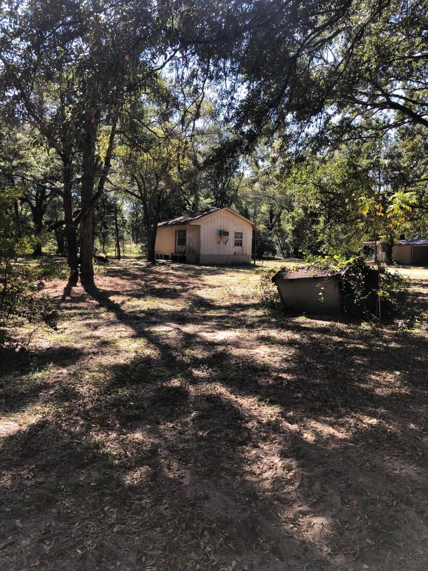 Three beautiful buildable lots shaded by mature oak trees offer the perfect setting for your Florida getaway or future home. The property is fully fenced and includes a small cabin with a covered outdoor area ideal for cleaning fish and parking your boat. A well, septic system, and power pole are already in place, providing a head start for development.The cabin is a true fixer-upper--ready for renovation or removal to make way for your dream build. No HOA and RVs are welcome. Centrally located near Freeport, Panama City Beach, and Santa Rosa Beach for easy access to beaches, boating, and shopping. Situated in Flood Zone X with no wetlands (buyer to verify).
