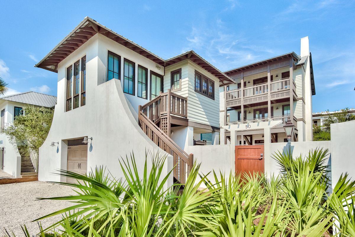 This is Costa Carina at its finest! Bordering the Rosemary Beach tennis courts, you'll feel like part of Rosemary but without any HOA fees! Step through the gate into the private courtyard covered in natural stone. The large pool and numerous poolside gathering areas will be a favorite among guests or renters. A set of French doors carry you into the first floor living space with professionally designed interiors, Thermador appliances, dining off screened porch, and elevator. The gas fireplace lends a striking compliment to the tall windows and abundance of natural light. Through a second set of French doors you're greeted with more outdoor living. Lush green Japanese Yew frames three sides and offers you a choice of gathering under the bistro lights or lounge in the fully