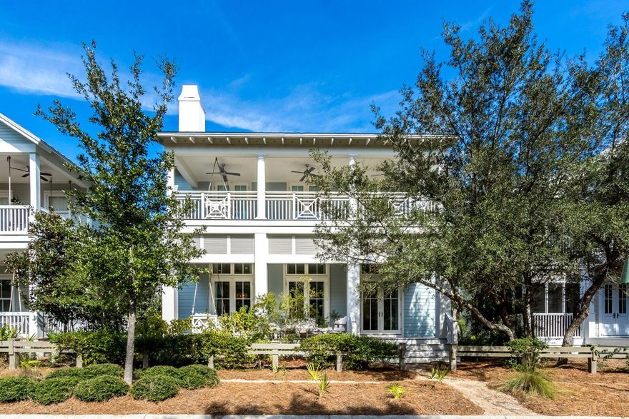 Tucked away along a remote stretch of Bluejack Street, this six-bedroom beach house overlooks pristine nature preserve and wooded walking trails offering added privacy in Phase 3 of WaterColor. This two-story beach cottage welcomes guests with an expansive covered front porch that boasts a swing bed and comfy outdoor living space made for enjoying life in WaterColor. A wall of double doors with transoms greets you as you enter the light and bright, open concept great room wrapped in shiplap and featuring beachy whitewashed wood floors. Offering a spacious seating area made for conversations, and a large living room space finished in coastal charm with a floor-to-ceiling seashell tabby gas fireplace; this space flooded with natural light was made for gathering and features soaring 12-foot