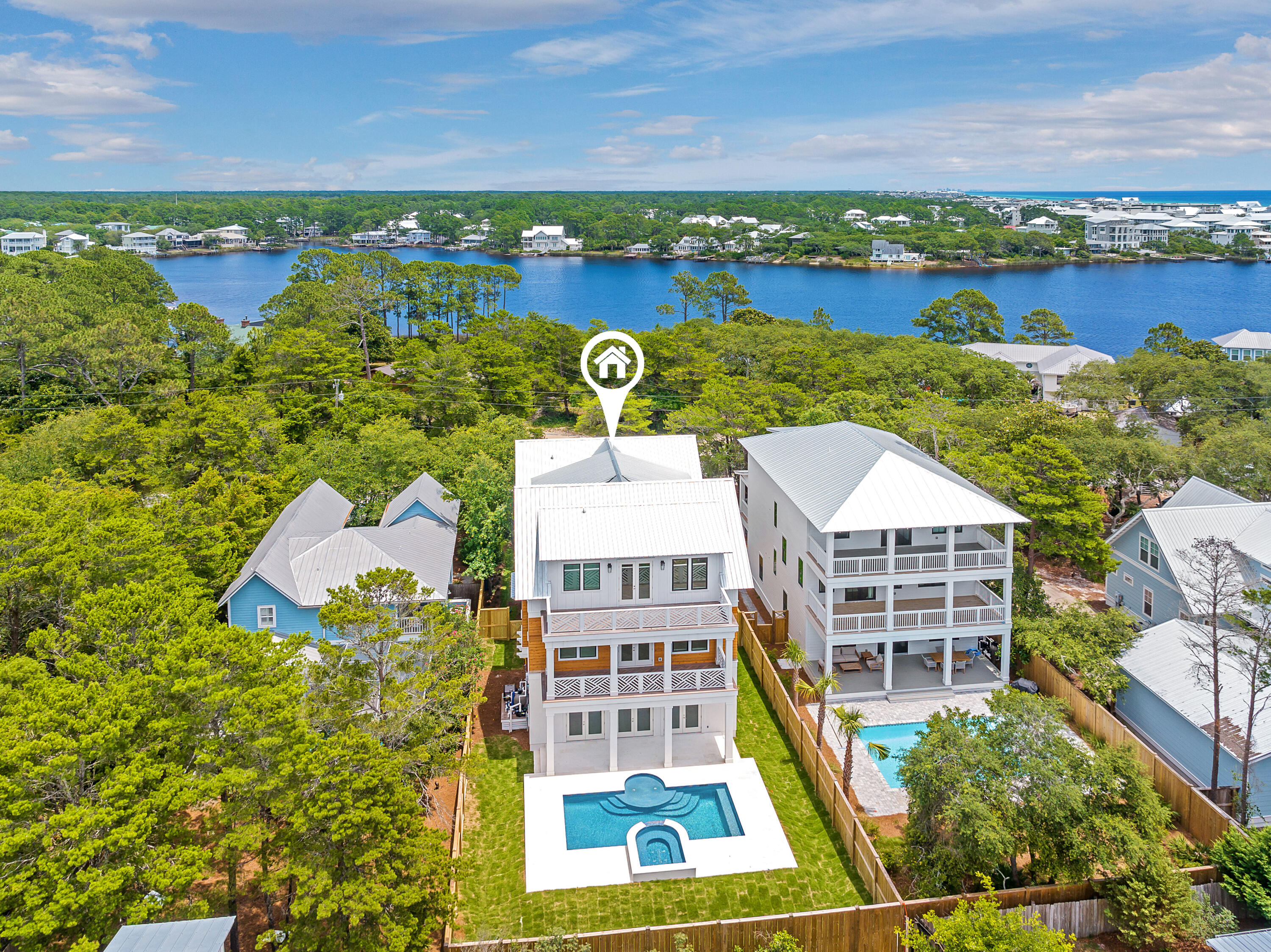 Stunning new construction home perfectly positioned in a prime Seagrove location within close proximity to large public beach access. Enjoy the spacious lot with a plethora of pavered parking, green space, large backyard with pool/hot tub combo, all with no HOA dues. This luxurious beach estate is the perfect combination of laid back living and upscale sophistication. The entry of the home greets you with a tiled front porch leading to the gorgeous arched mahogany front doors. The main level was designed for entertaining with its high ceilings and large open floor plan that includes the living room, kitchen, and dining area. Large doors blend this space seamlessly to the outdoor pool deck where you will find a very accommodating pool plus an integrated hot tub with waterfall feature. The living room space is adorned with a gas fireplace, wet bar with 2 wine/beverage refrigerators, shiplapped walls and white coffered 12' ceilings. The well appointed kitchen comes complete with a Thermador appliance package, beautiful tile backsplash wall that runs to the ceiling, marble counters with gold accents, and a hidden walk-in pantry! White oak flooring and shiplapped walls round off the coastal feel and run throughout the home. Perhaps one of the best features of the main level is 2 garages! You will also find a 1/2 bath and 3 stop elevator on the first floor for added convenience. The second floor has a large master suite with private porch, huge walk-in closet, and grand master bath. Adjacent to the stairs you will find a large flex space, offering a multitude of opportunities. This space also has a 1/2 bath beside it making it great for a bunk room conversion or living area. The east end of the second level contains 2 guest bedrooms, both with ensuite baths. There's also a very spacious laundry room on this level. The 3rd floor is a similar reflection of the 2nd. It consists of another primary suite with private porch. There's also additional laundry hookups in the primary closet. The flex space on this level is also filled with opportunity to transform into a bunk area, game room, office, or living room. The east end of this floor has 2 guest rooms and a shared bath. All closets throughout the home have wood built-ins. The home was constructed with extreme attention to detail and high-quality finishes, including Ipe wood decking. Enjoy prime Seagrove living with the Eastern Lake public beach access being just under 900 feet away where the county has assembled over 6 acres of beach. This beach access also allows for access to Eastern Lake and its outfall to the gulf, making it a very unique experience. Seagrove is centrally located along 30A with close proximity to Seaside, restaurants, shops, and all that the 30A has to offer.